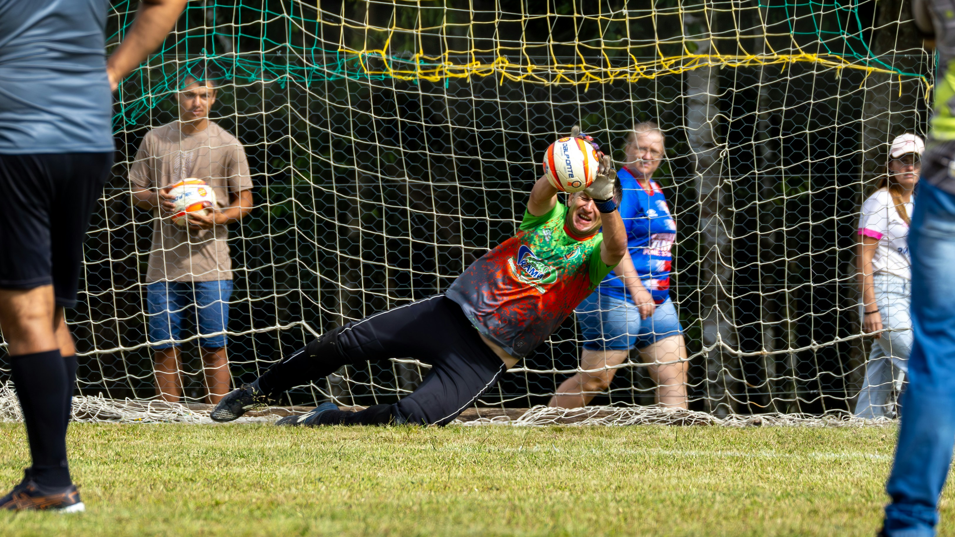 Arquero lanzándose para evitar un gol en un partido cerrado