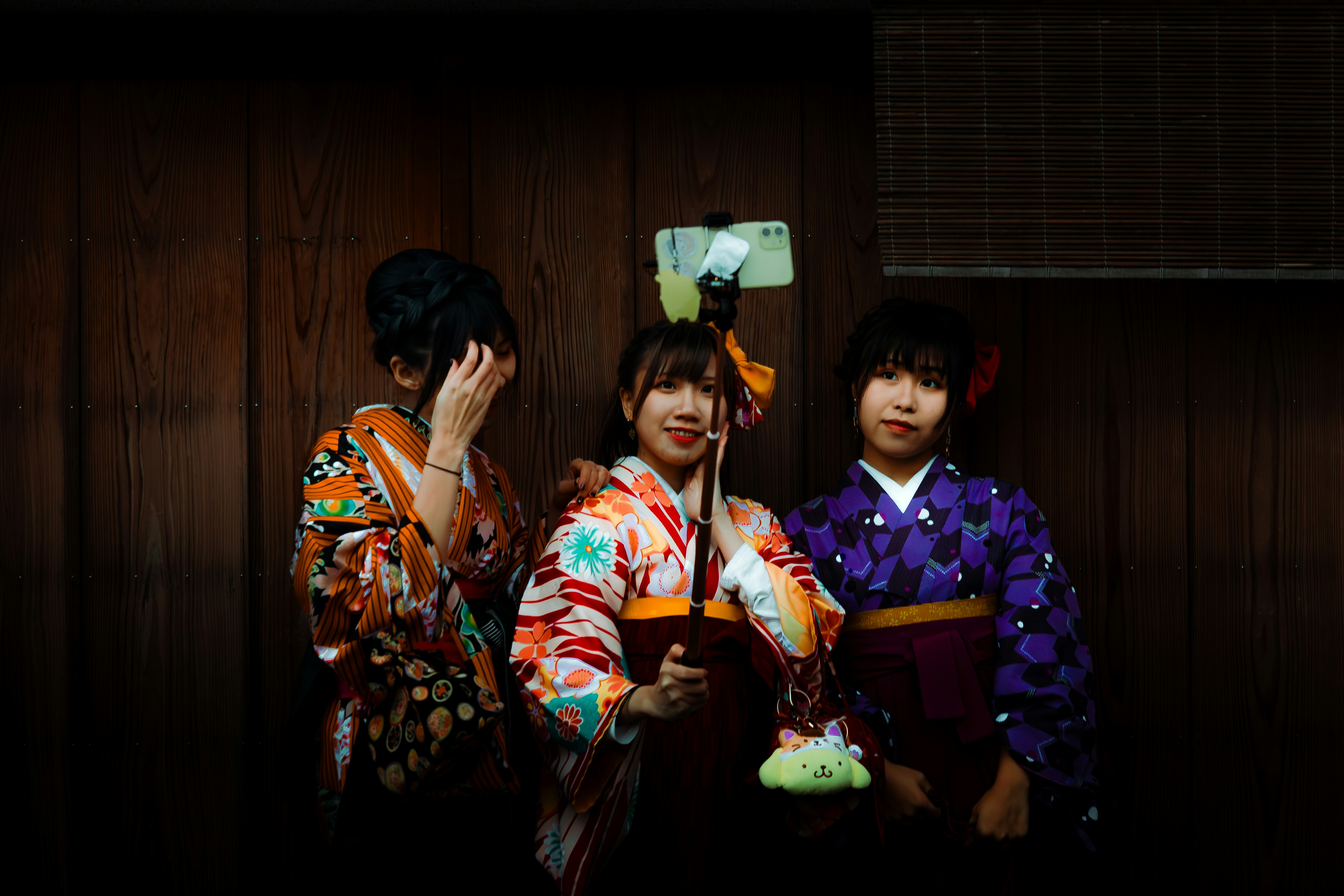Three women in traditional kimonos taking a selfie.