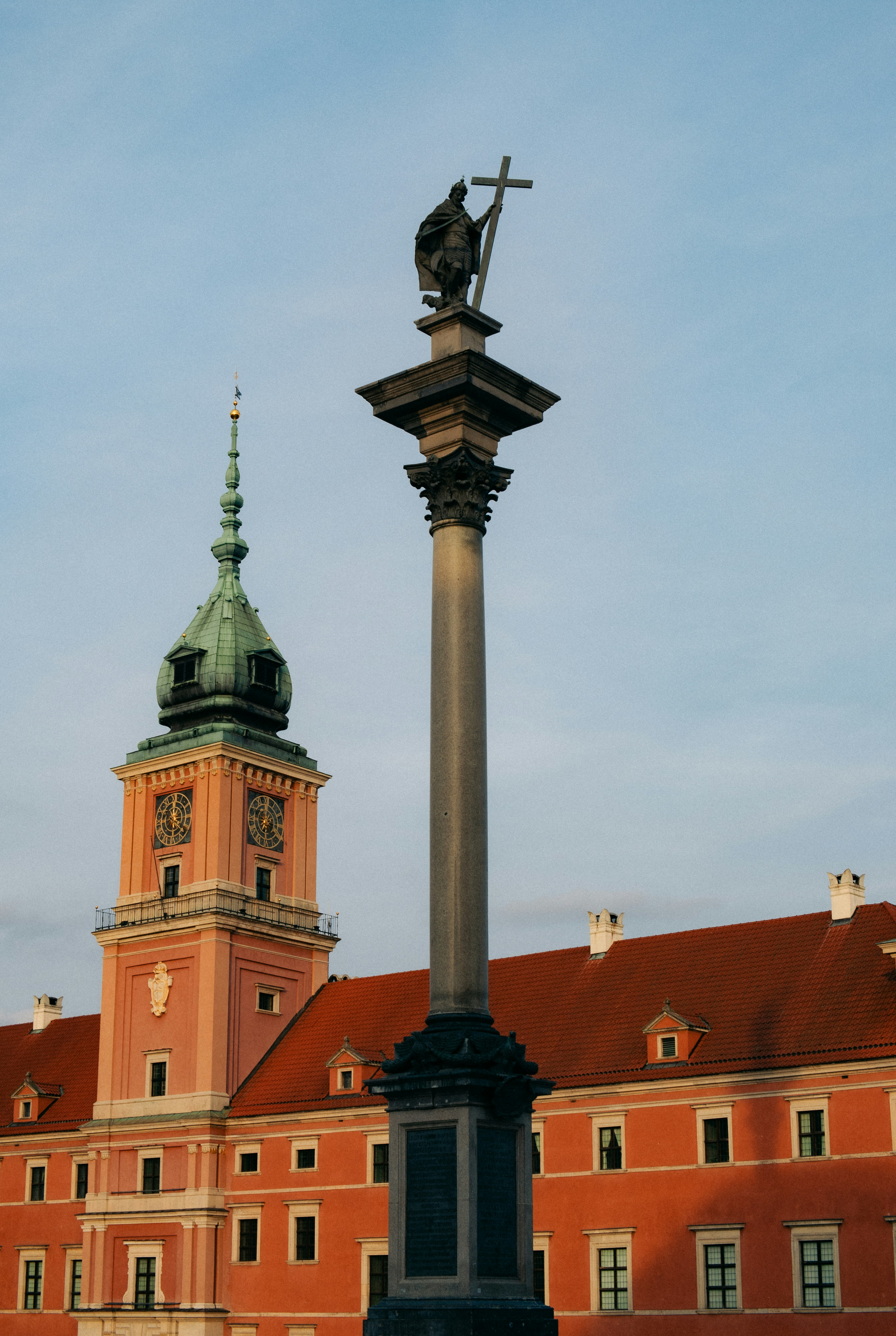 Column with statue in front of a pink building