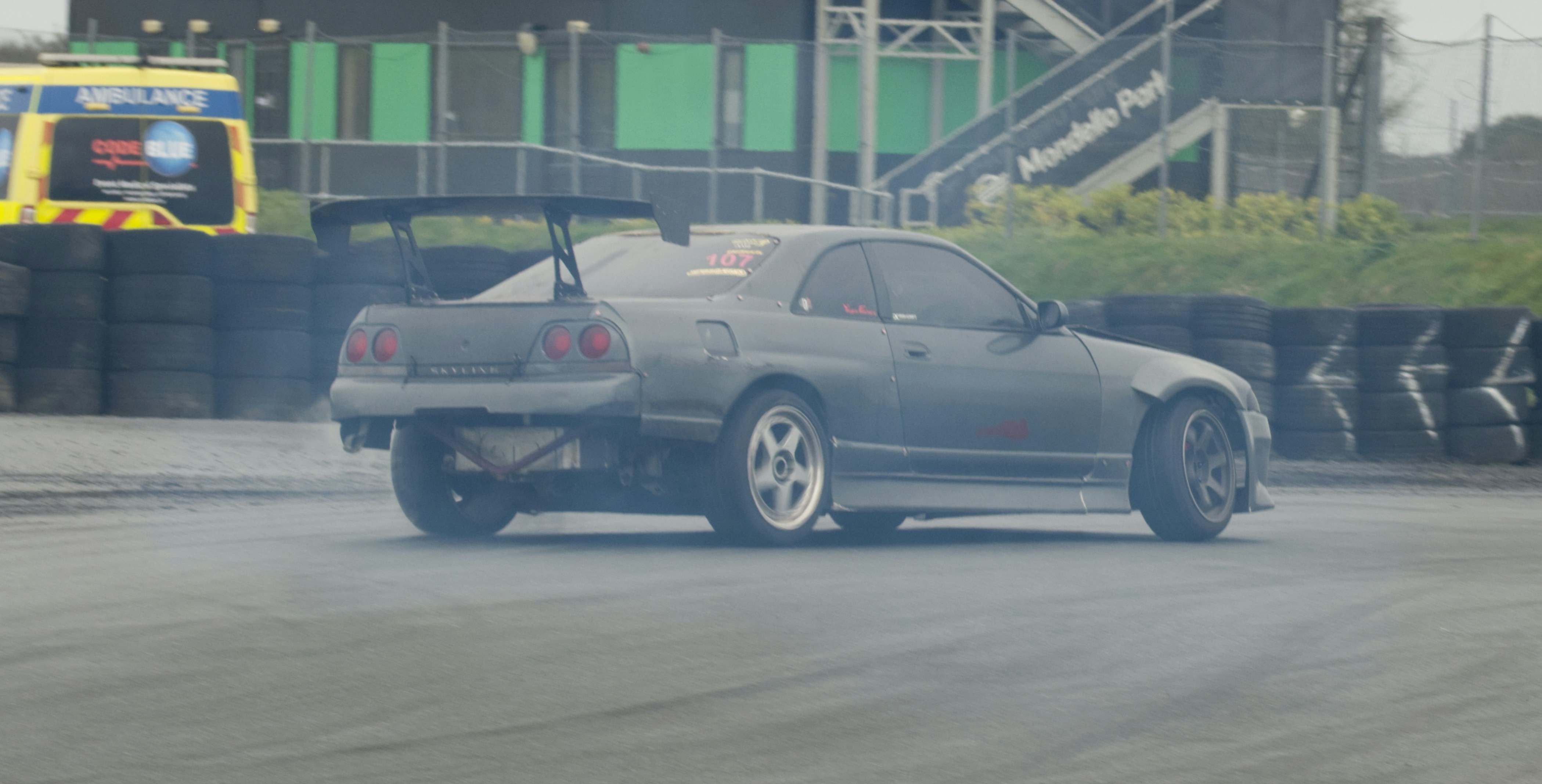 Drifting car kicking up smoke on a track