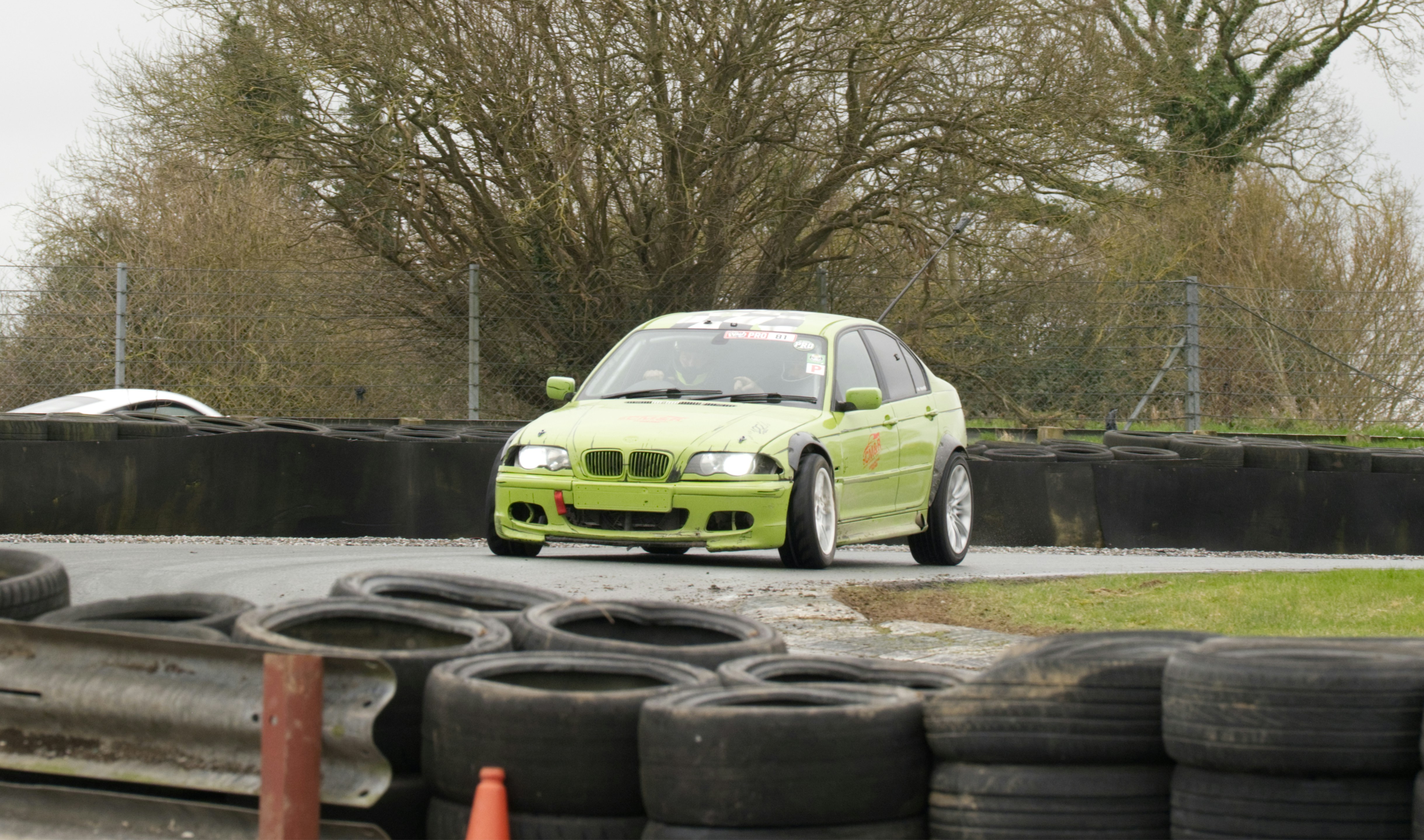 A lime green car races on a track.
