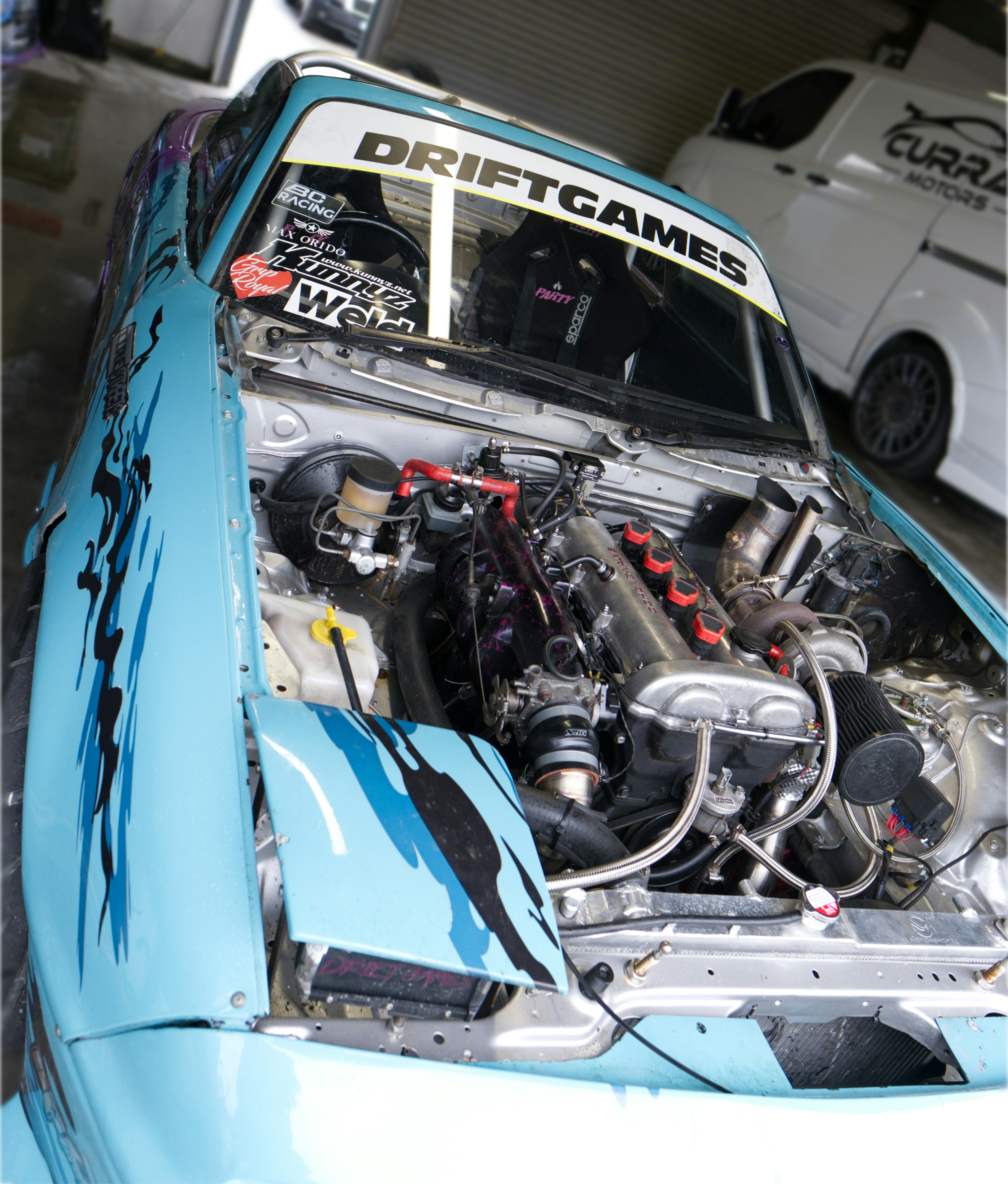 Custom drift car with exposed engine and blue graphics