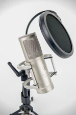 A studio microphone on a stand with pop filter