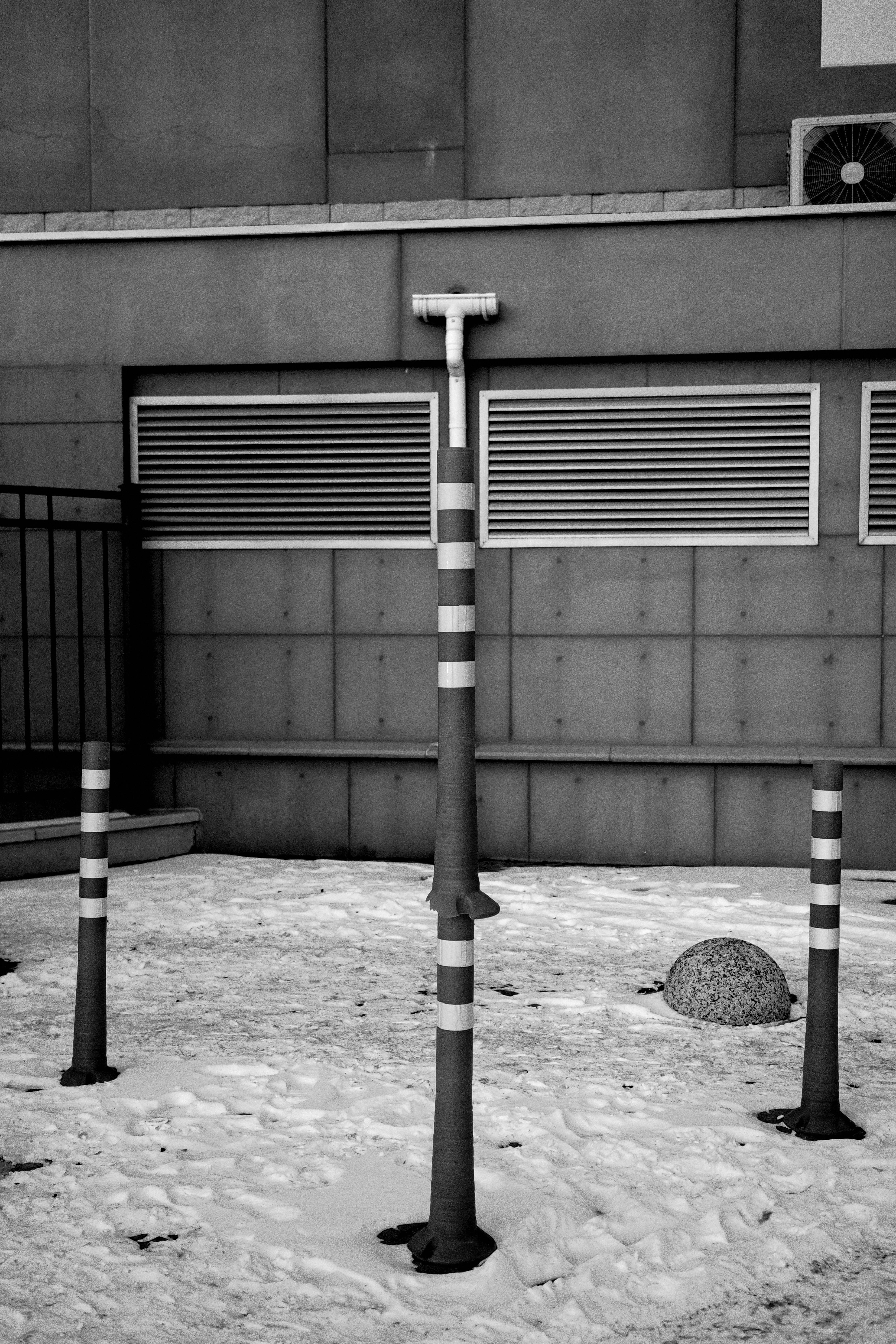 Trois bornes rayées se dressent dans la neige.