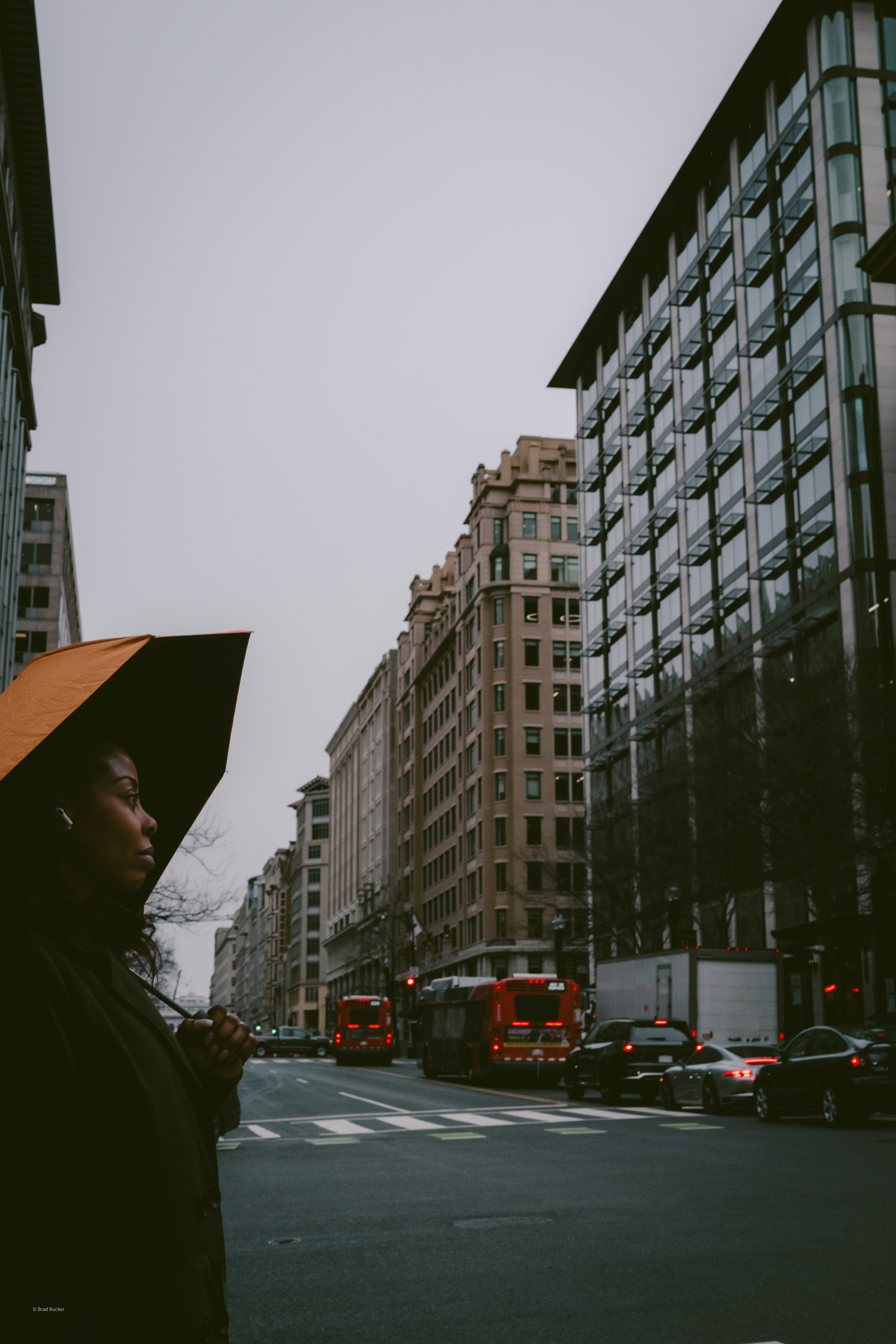 A woman with an umbrella on a city street.