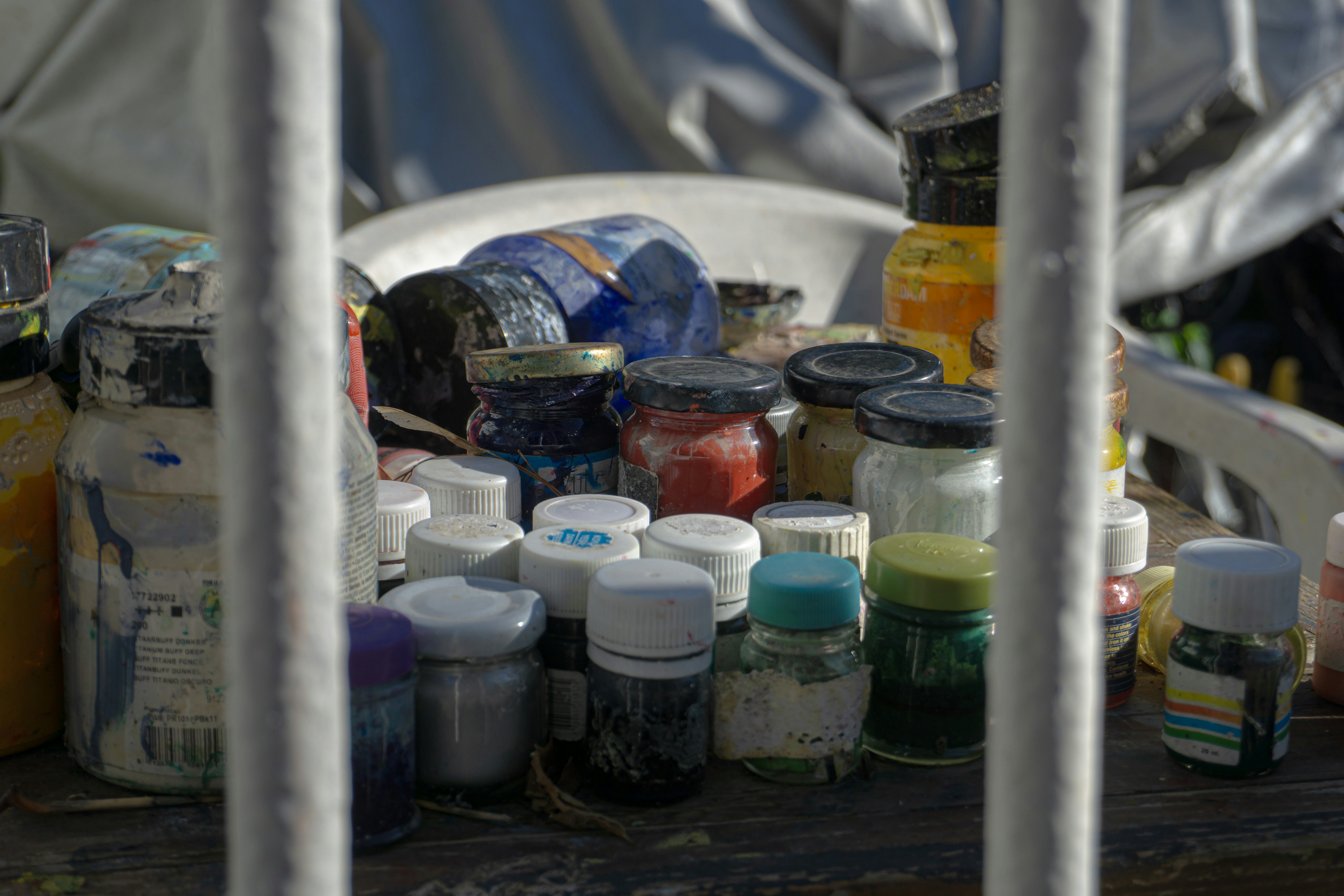 Assortment of paint bottles and jars on a table.