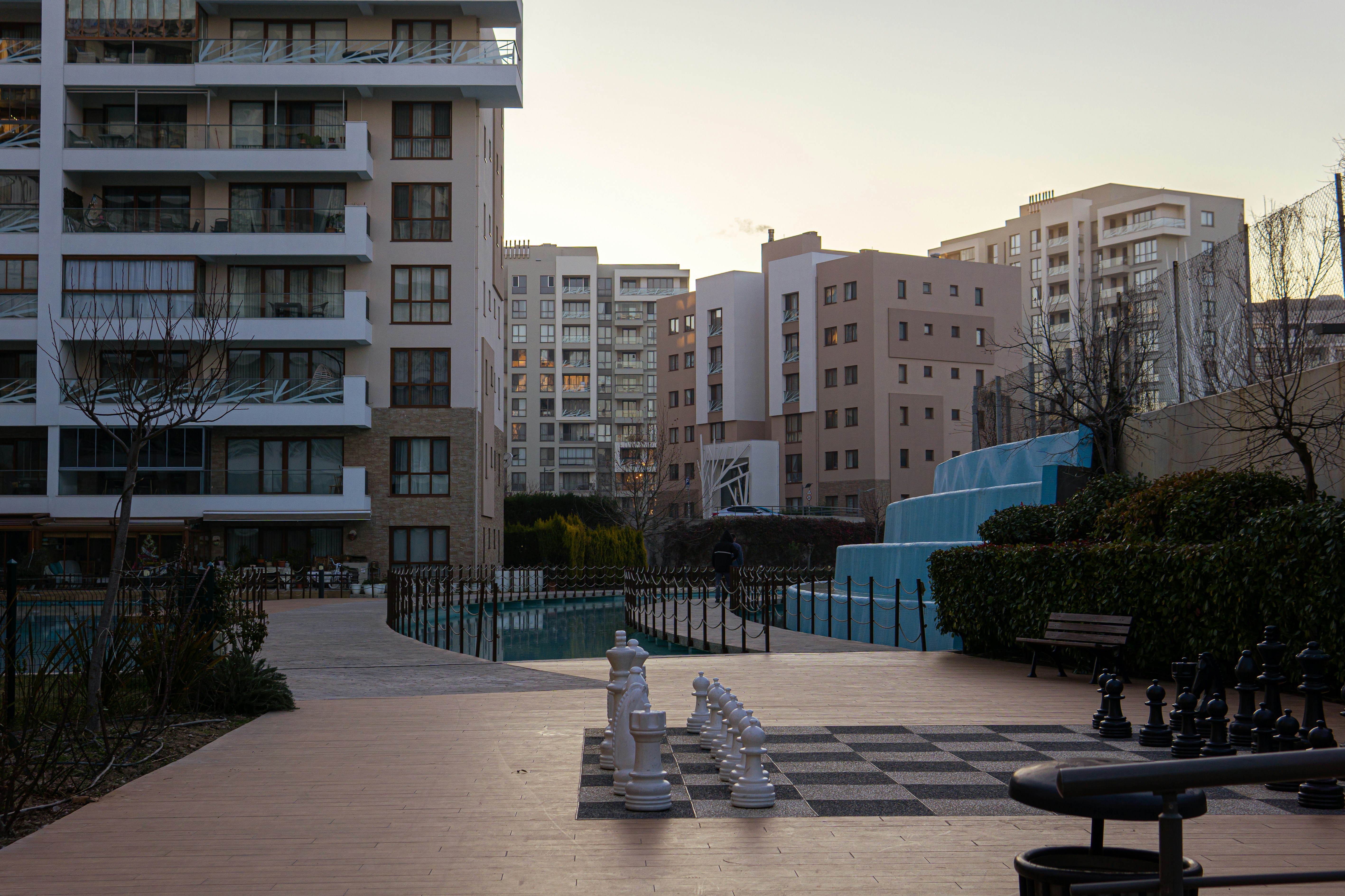 Apartment buildings and outdoor chess set at dusk.