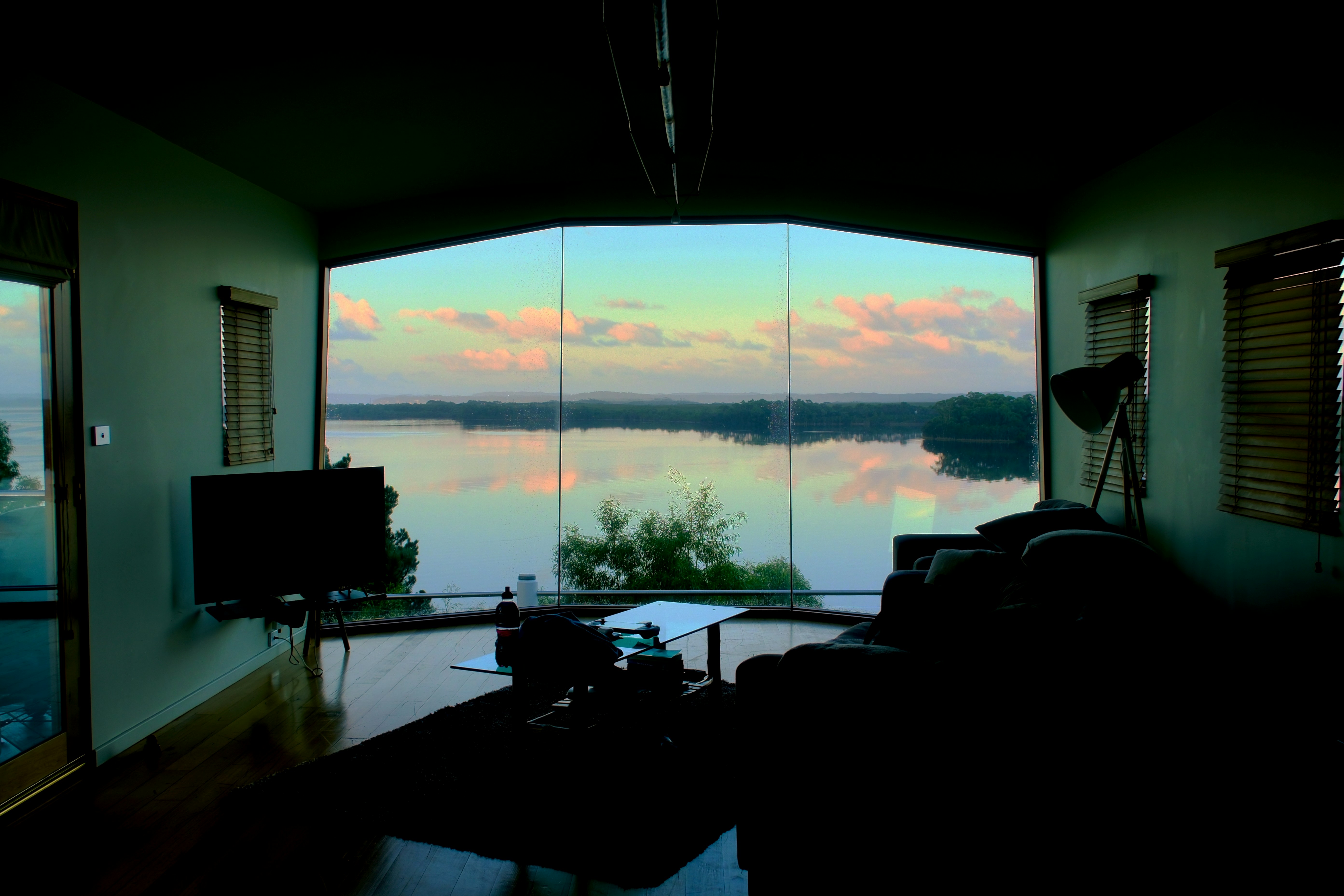 Salón con gran ventana que da al lago al atardecer