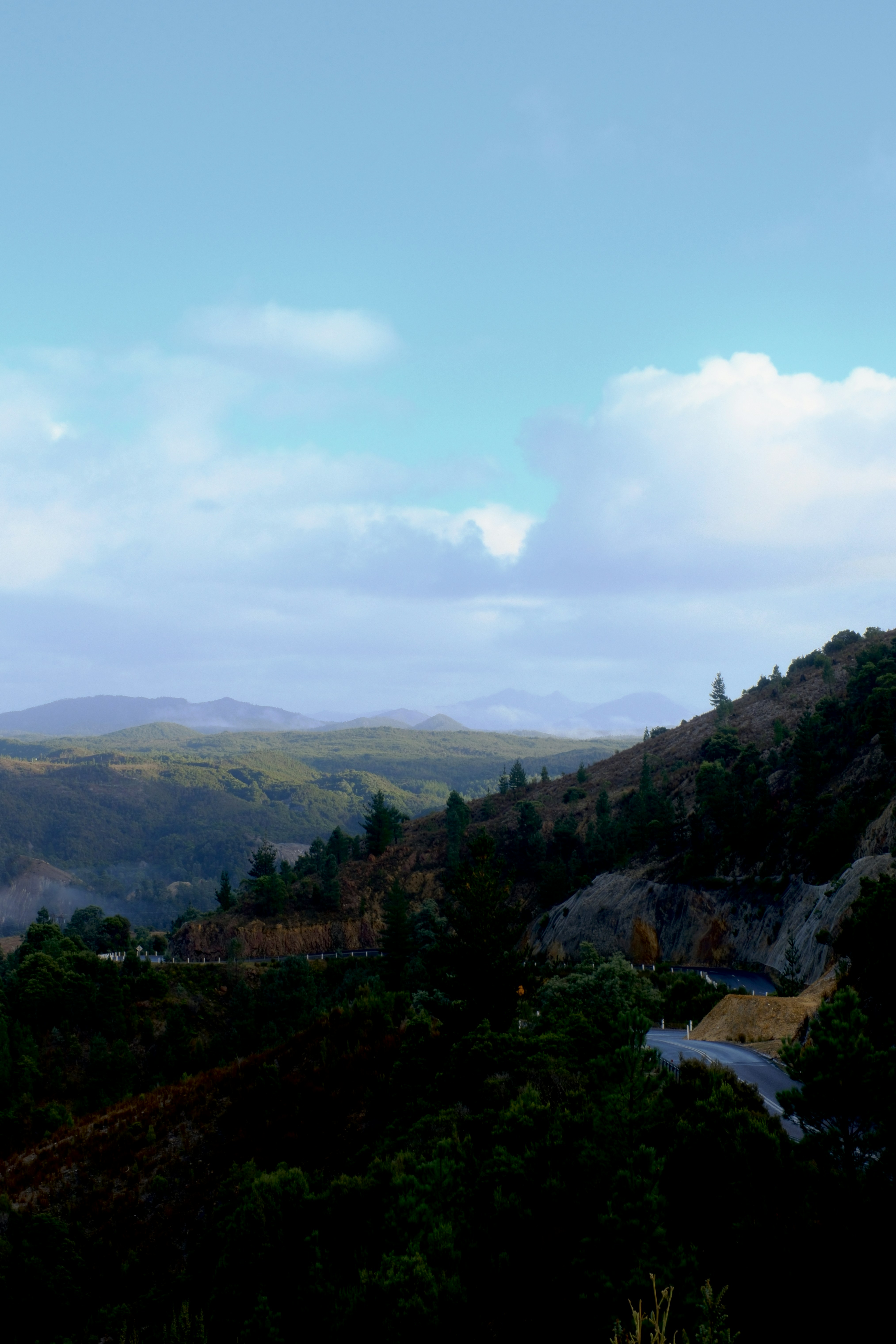 Colinas onduladas y una carretera sinuosa bajo un cielo nublado
