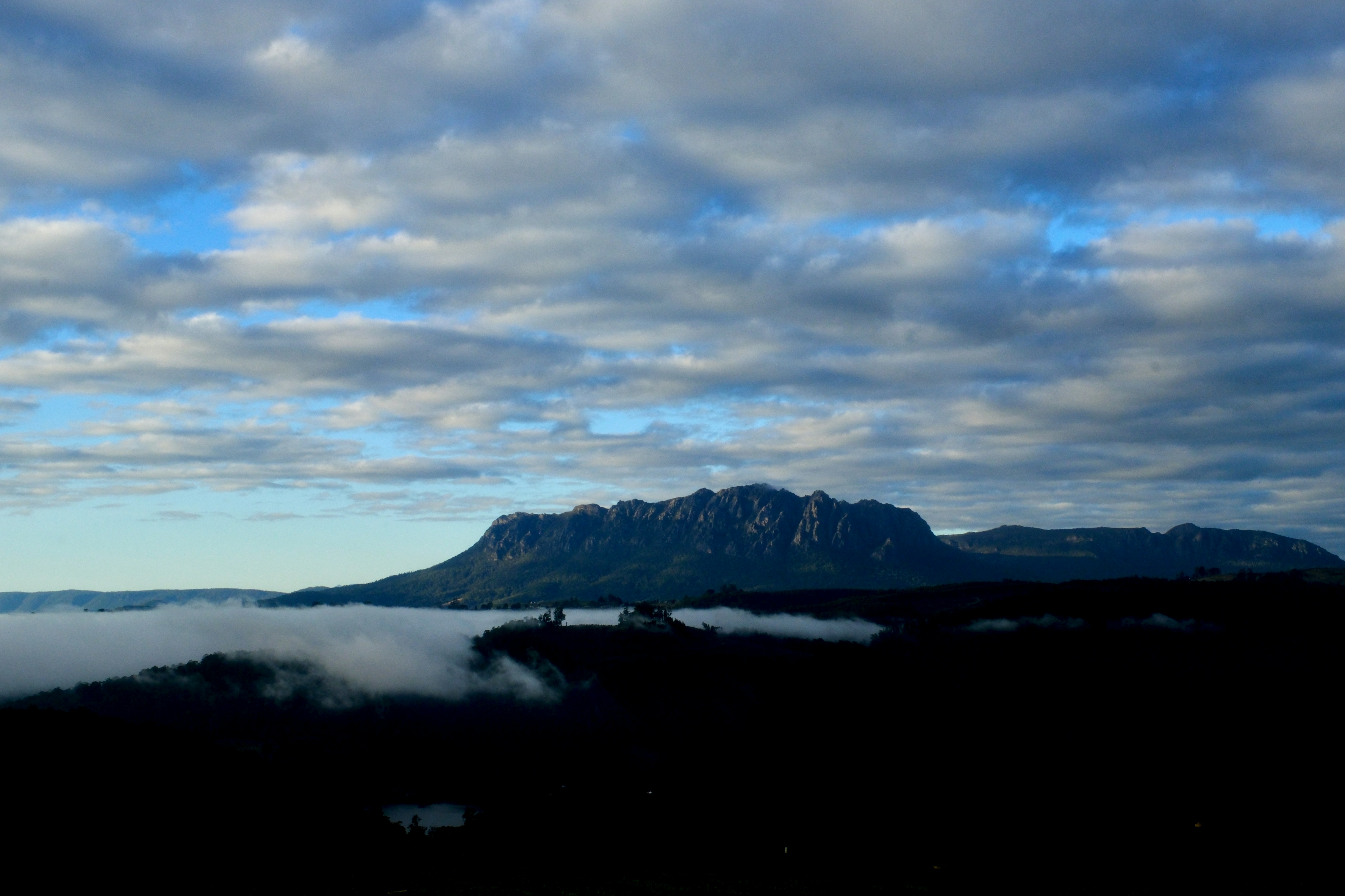 La cordillera emerge de una niebla baja bajo un cielo nublado
