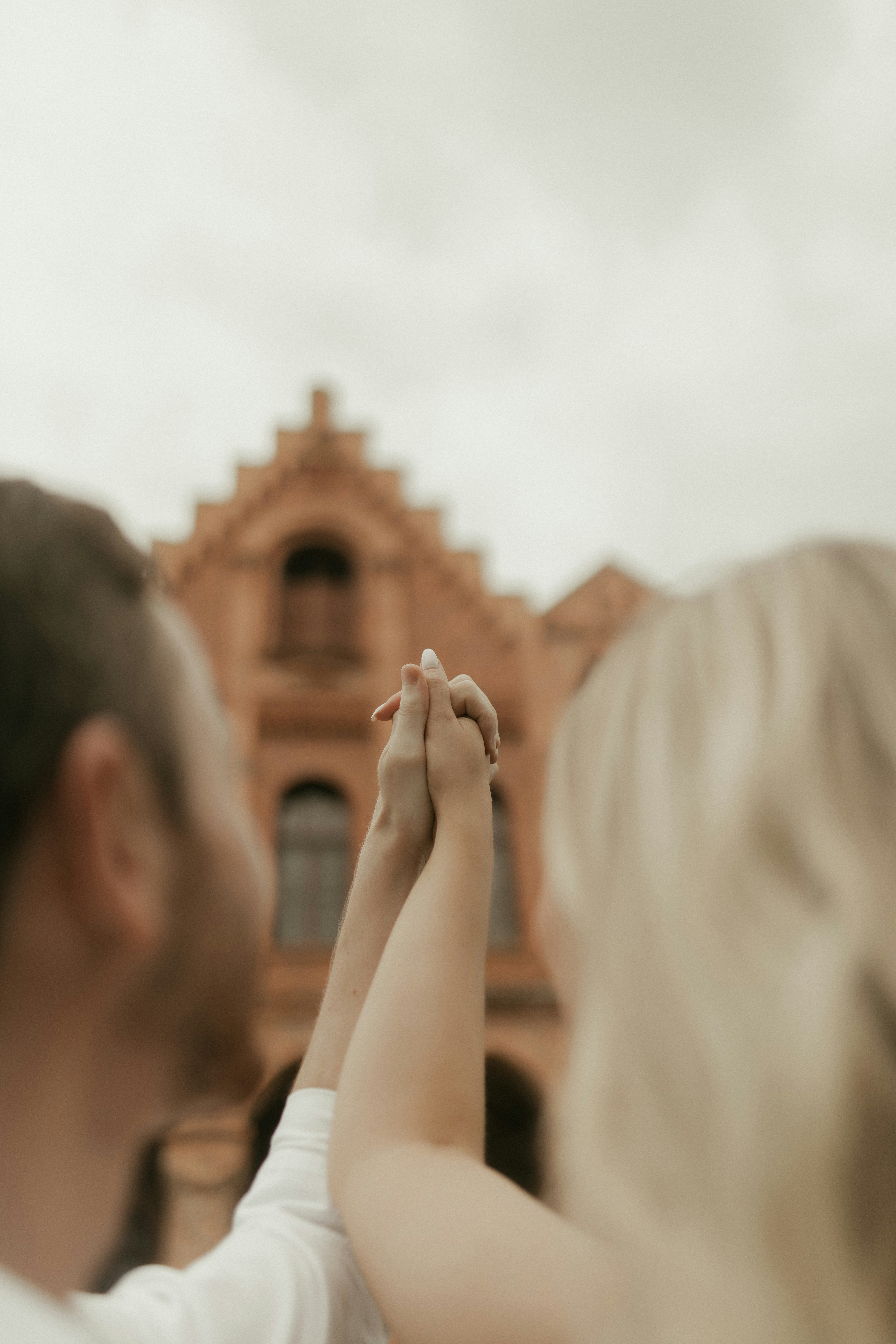Couple holding hands in front of historic building