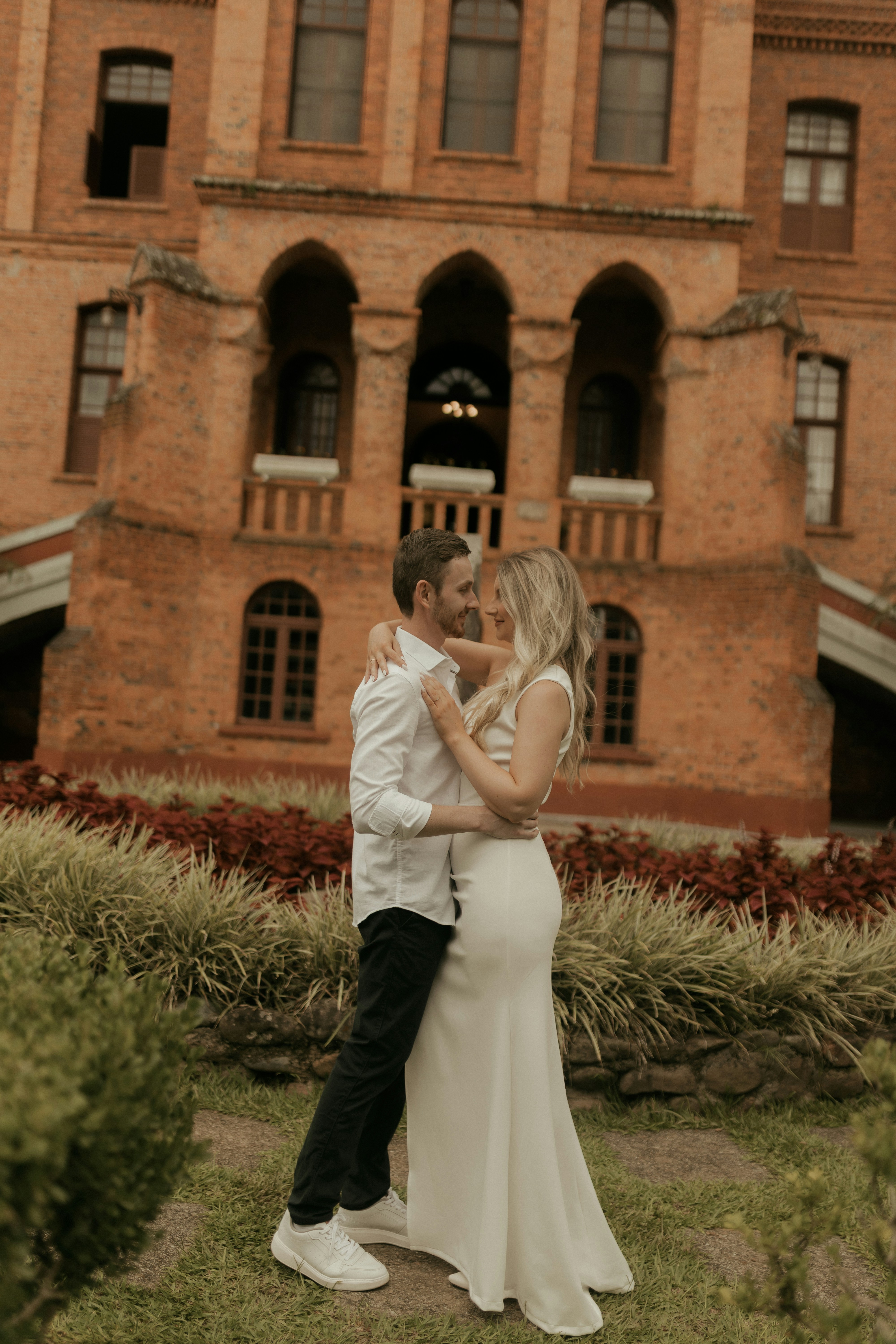 Couple embracing in front of a brick building