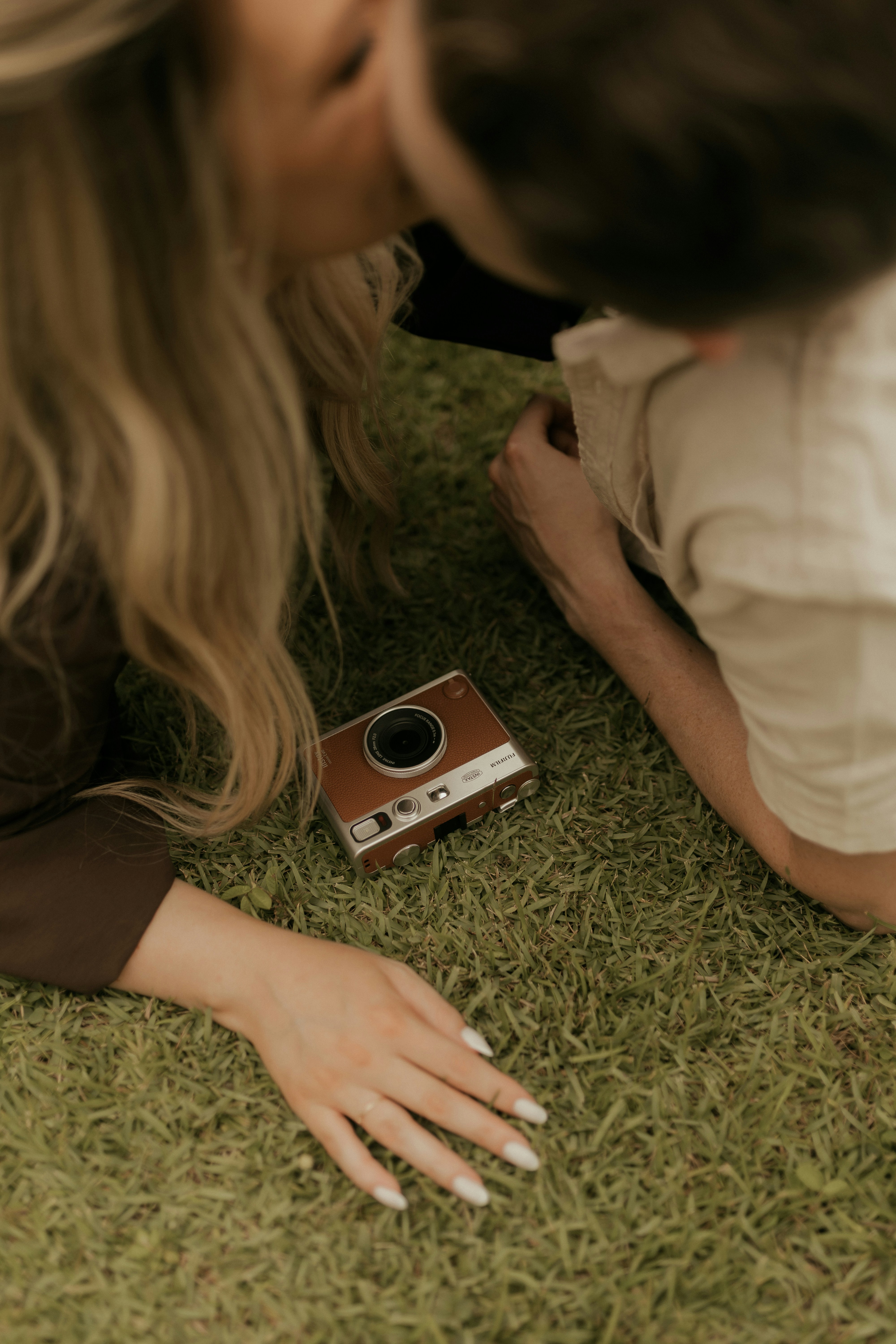 Couple with vintage camera lying on grass