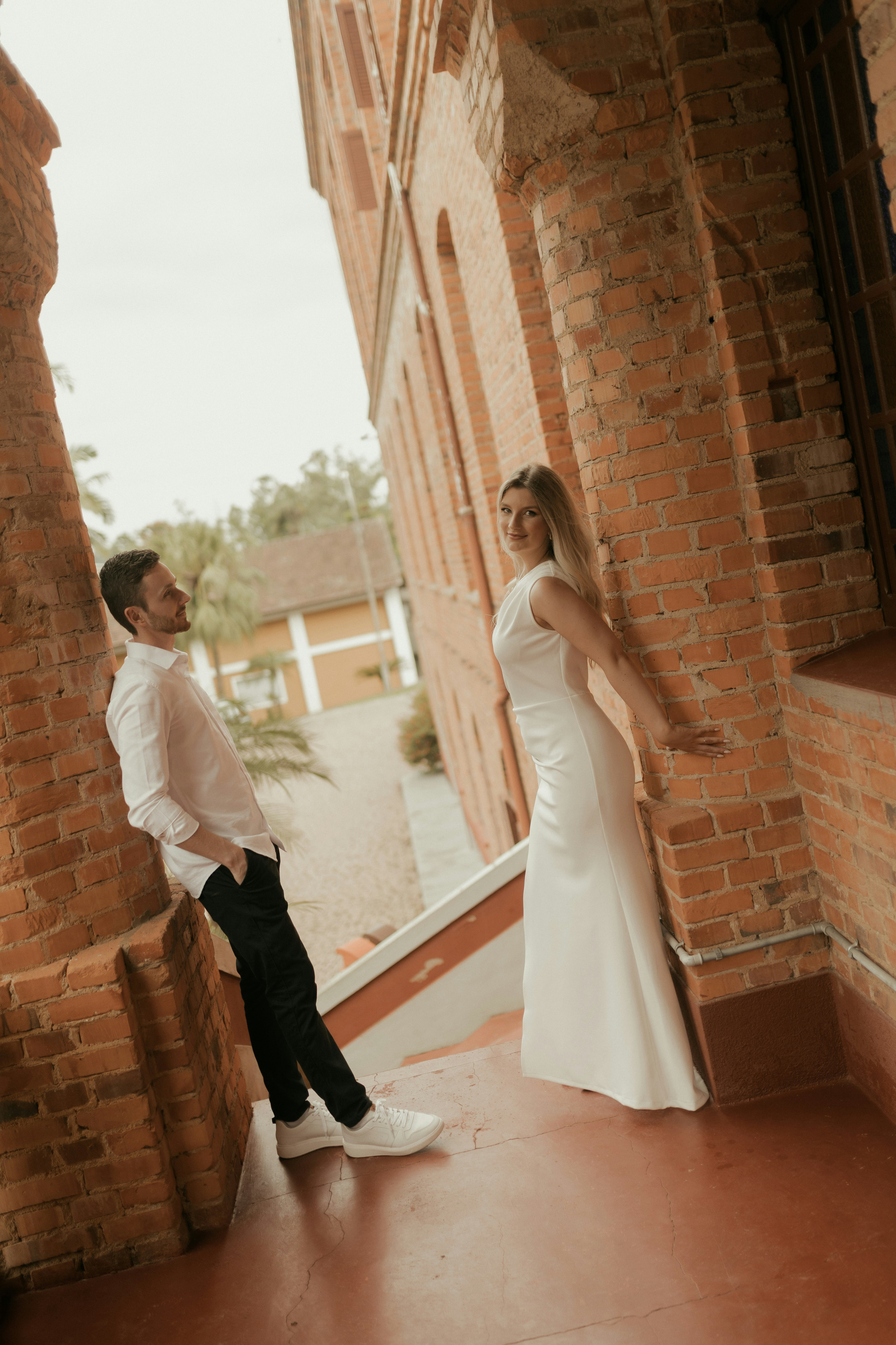 Couple posing by a brick building