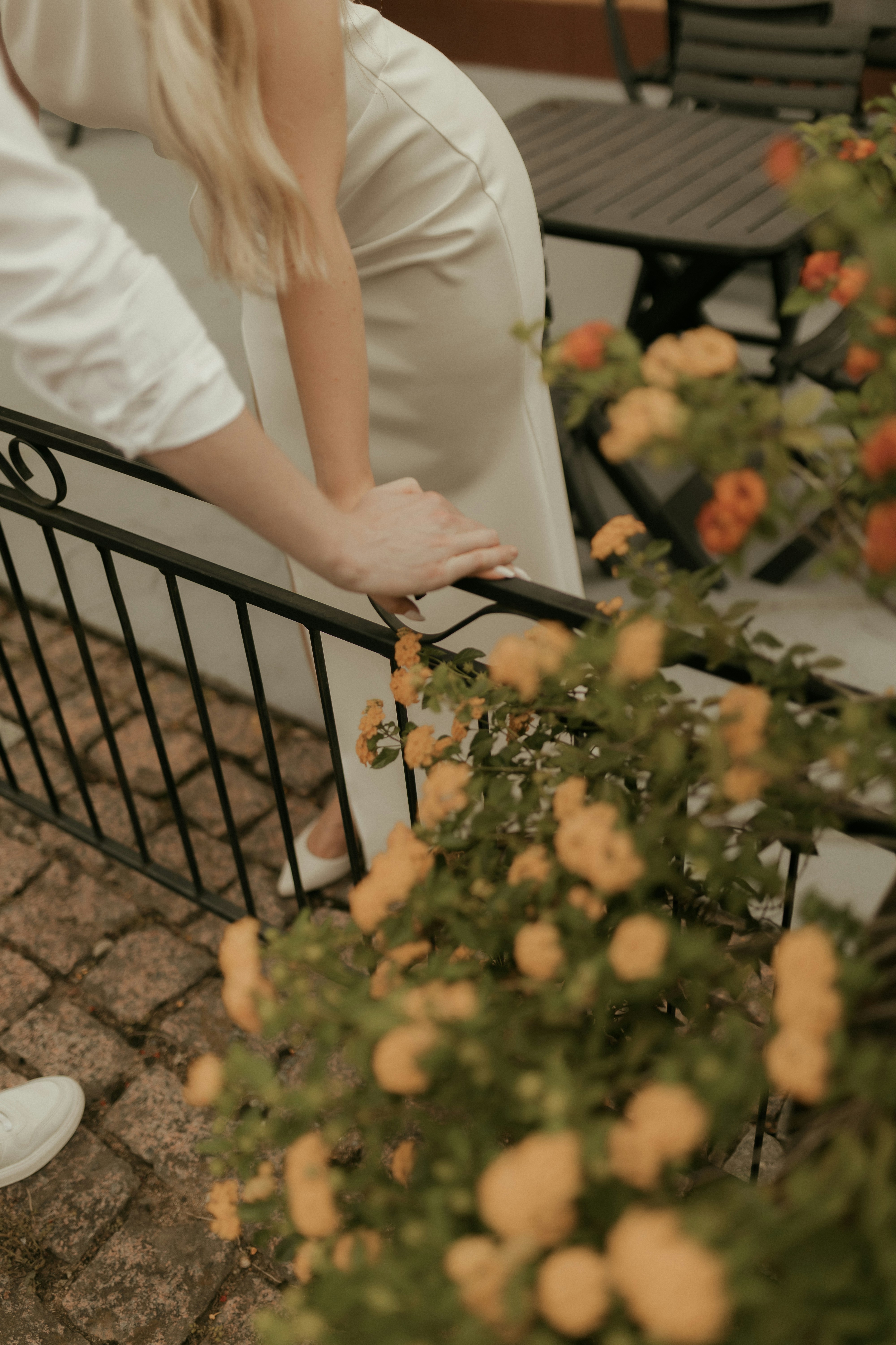 Couple holding hands by a railing with flowers
