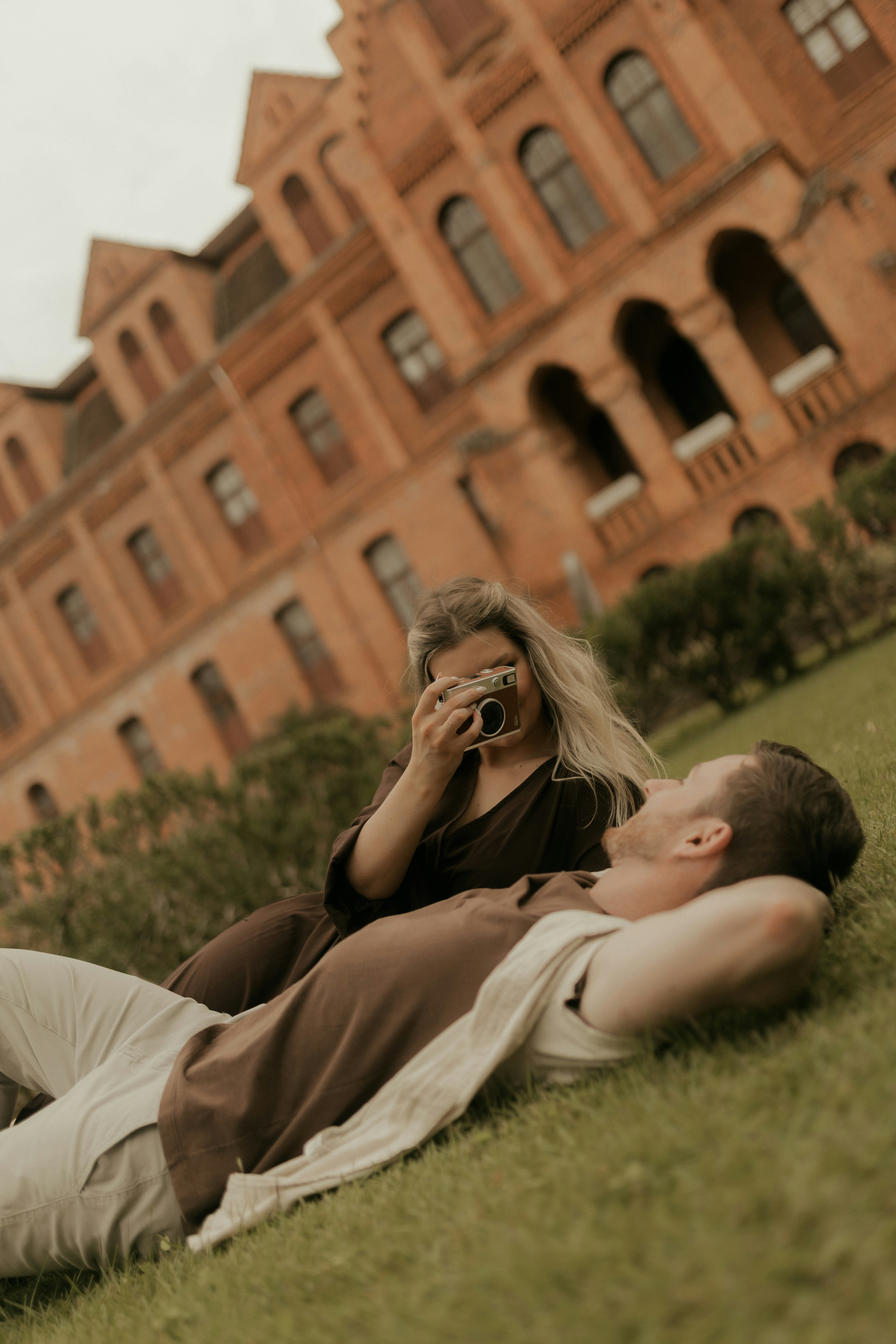 Couple taking a photo in front of a brick building