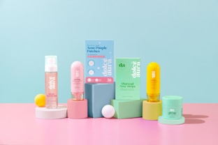 Assortment of skincare products arranged on pastel blocks.