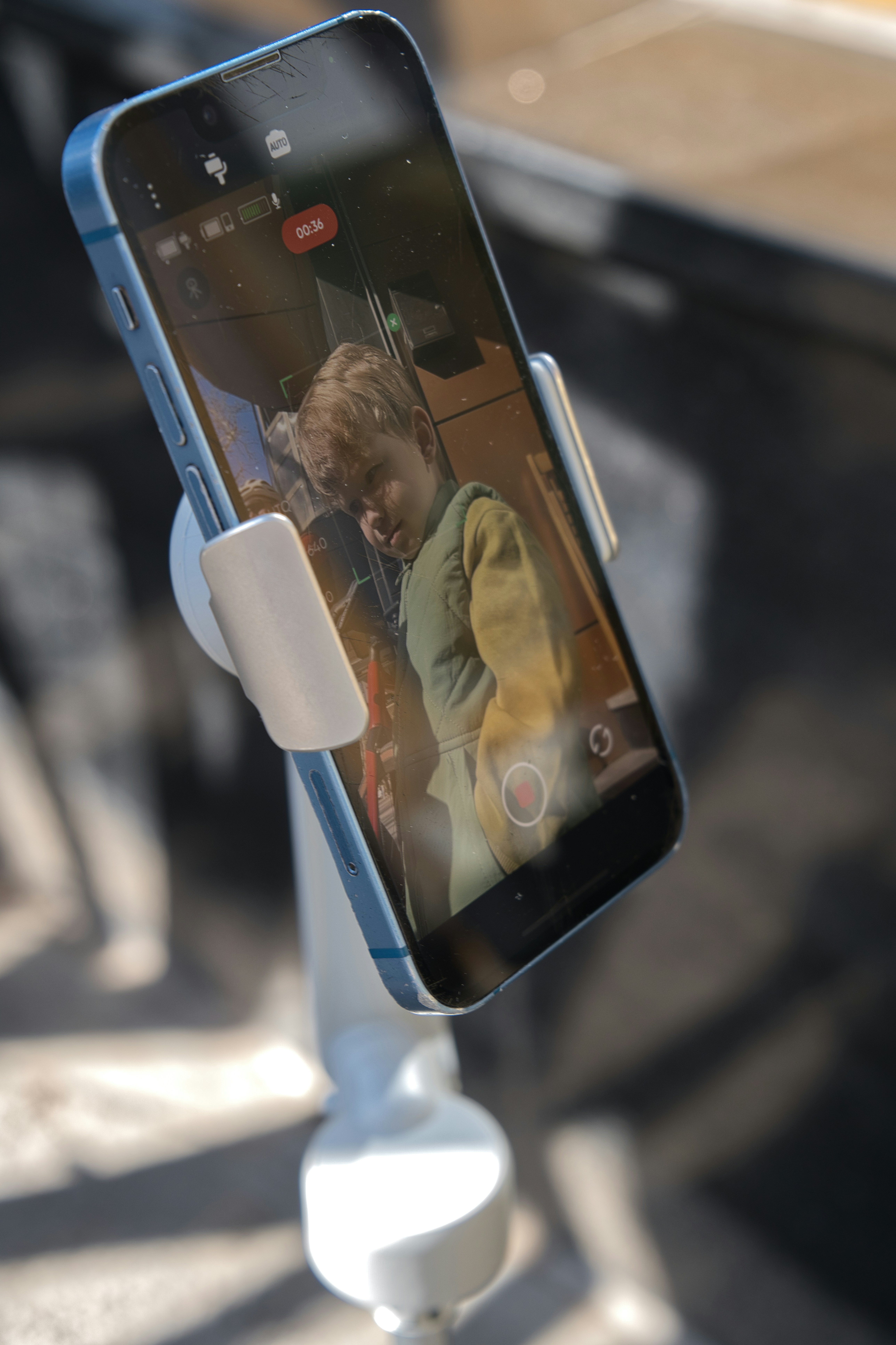 Smartphone screen displays a young child's face.