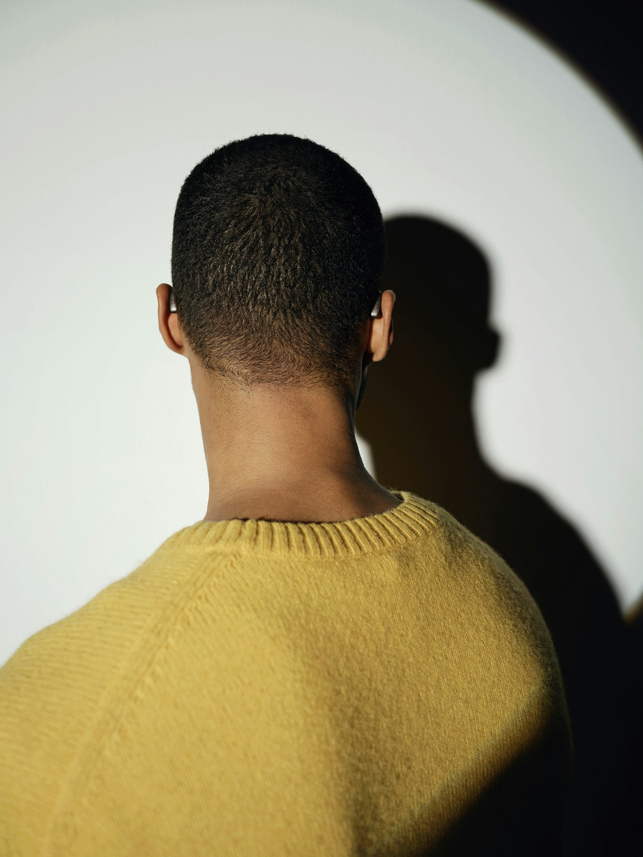 Back of man's head wearing a yellow sweater