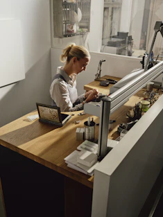 Woman working at a jewelry making bench.