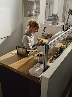 Woman working at a jewelry making bench.