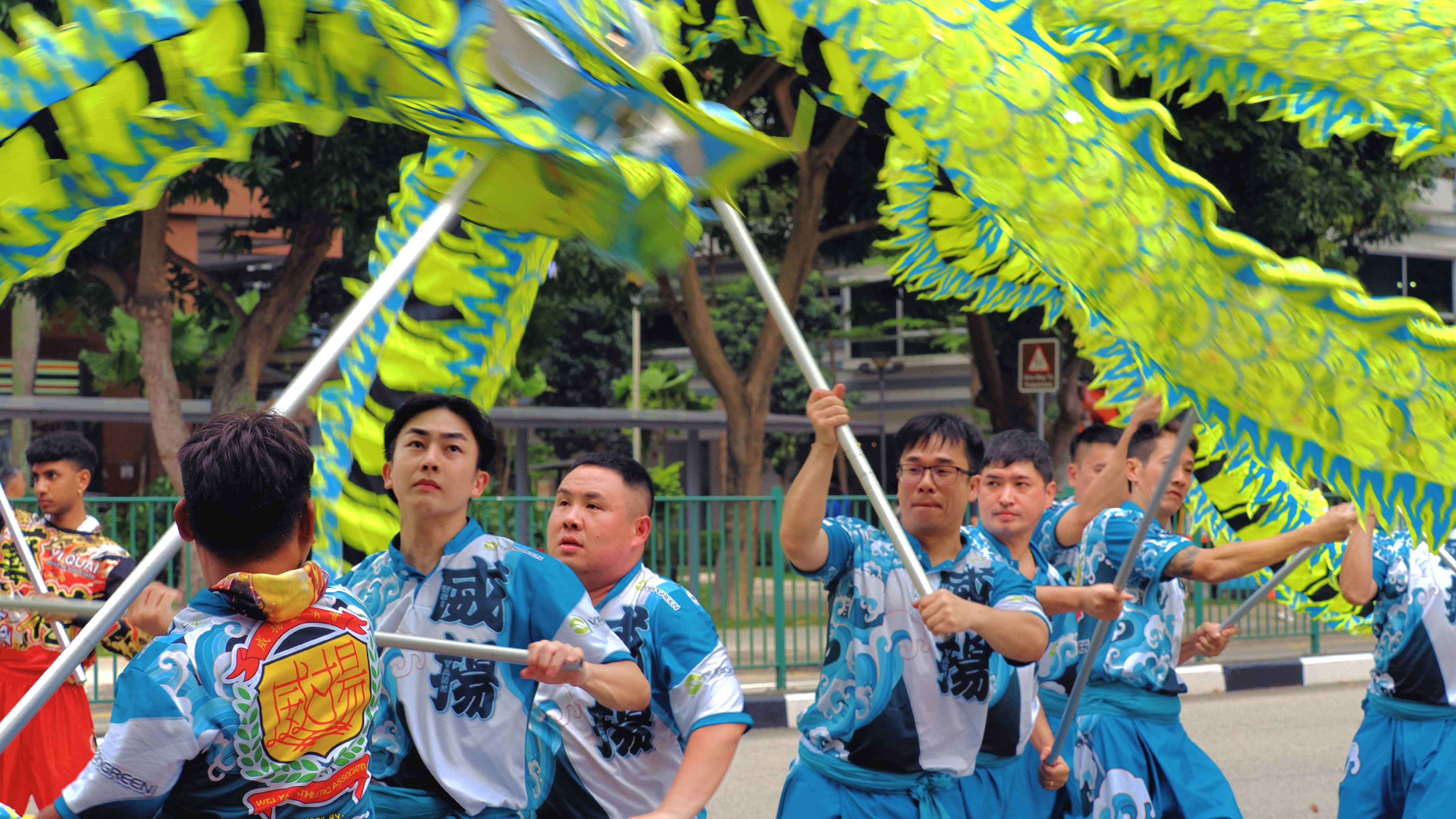 Orang-orang memegang naga hijau besar selama parade.