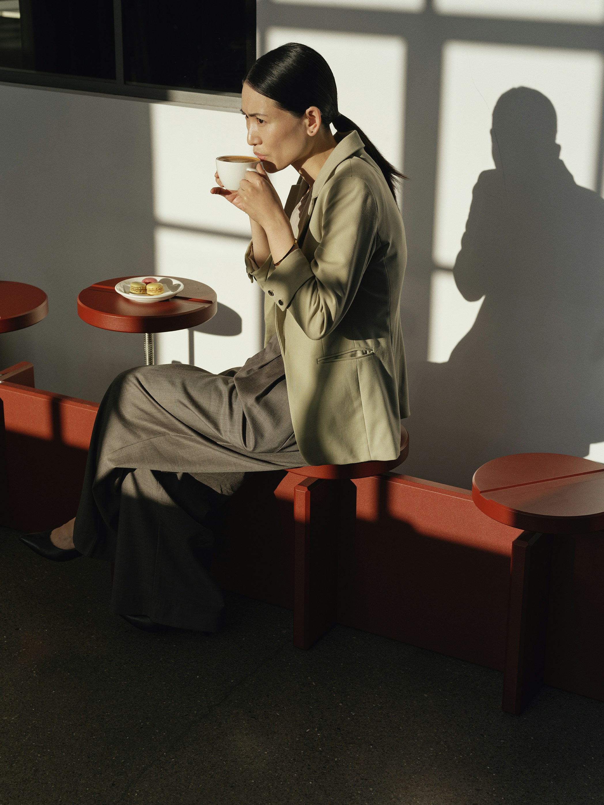 Woman drinking coffee in a sunlit cafe