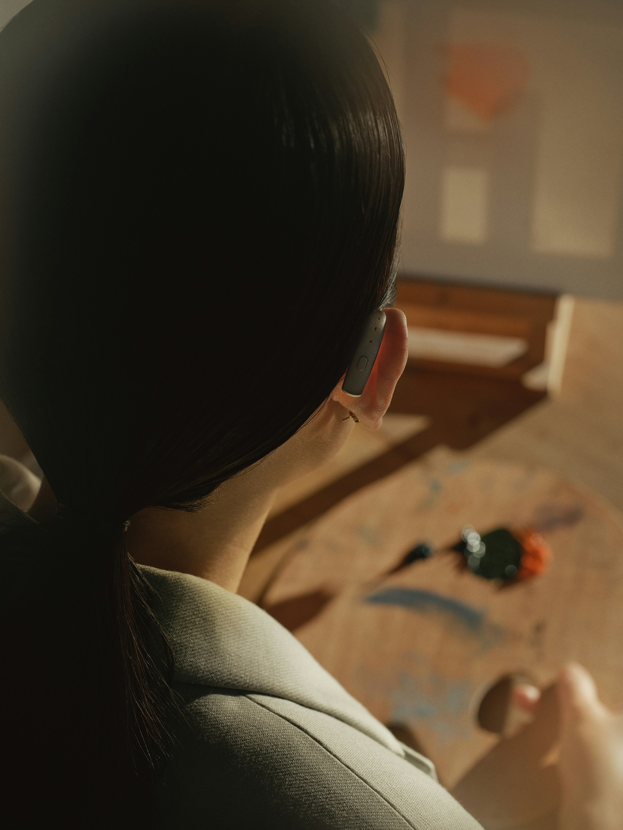 Artist painting on a wooden easel with colorful palette.
