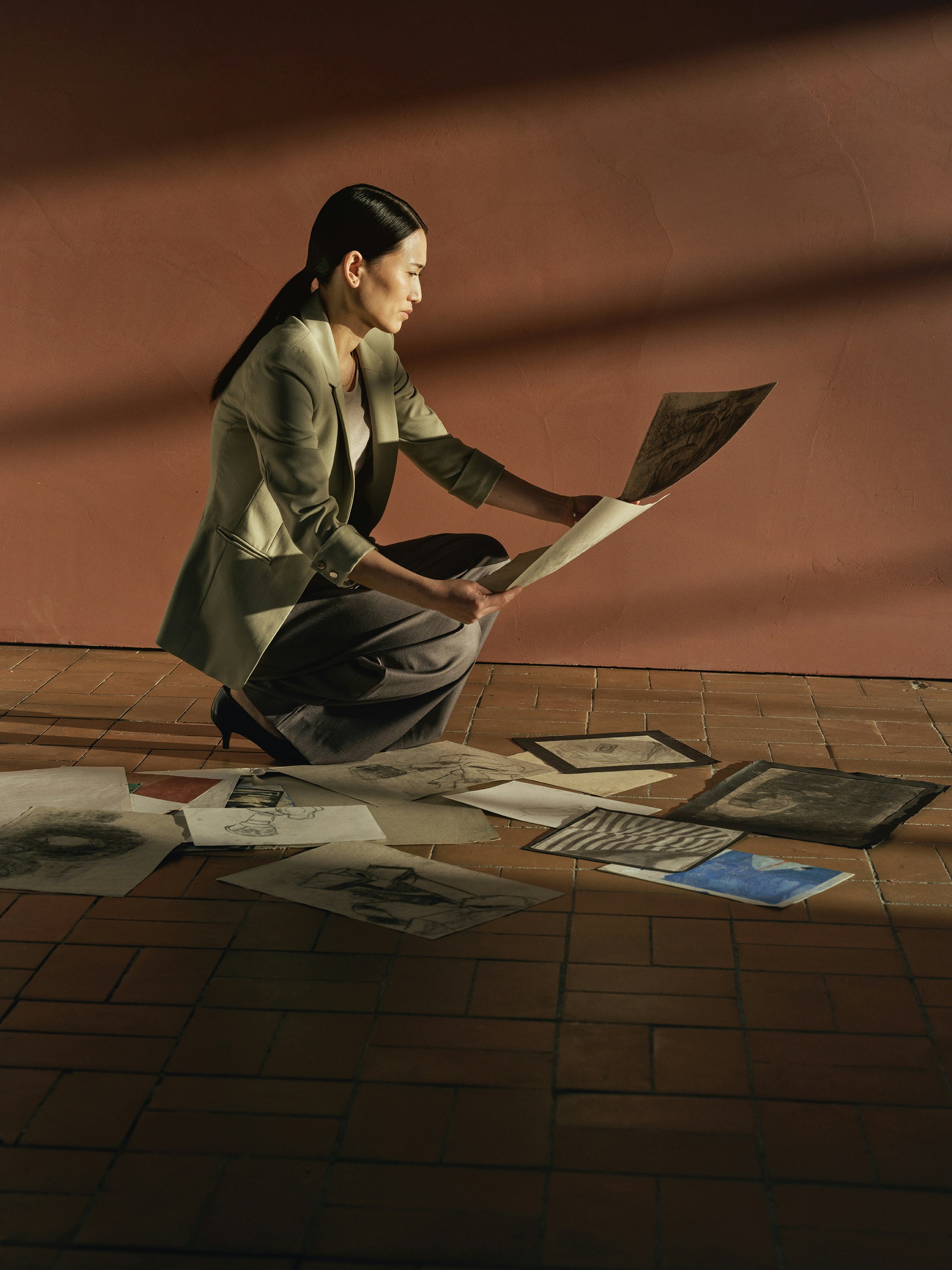Woman reviewing artwork spread on the floor