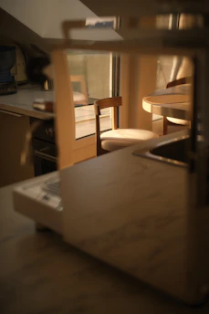 A kitchen counter with a coffee machine and chair.