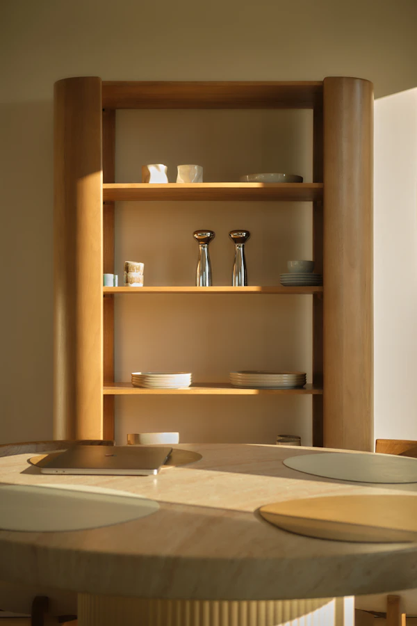 Wooden shelf of kitchenware above a round table