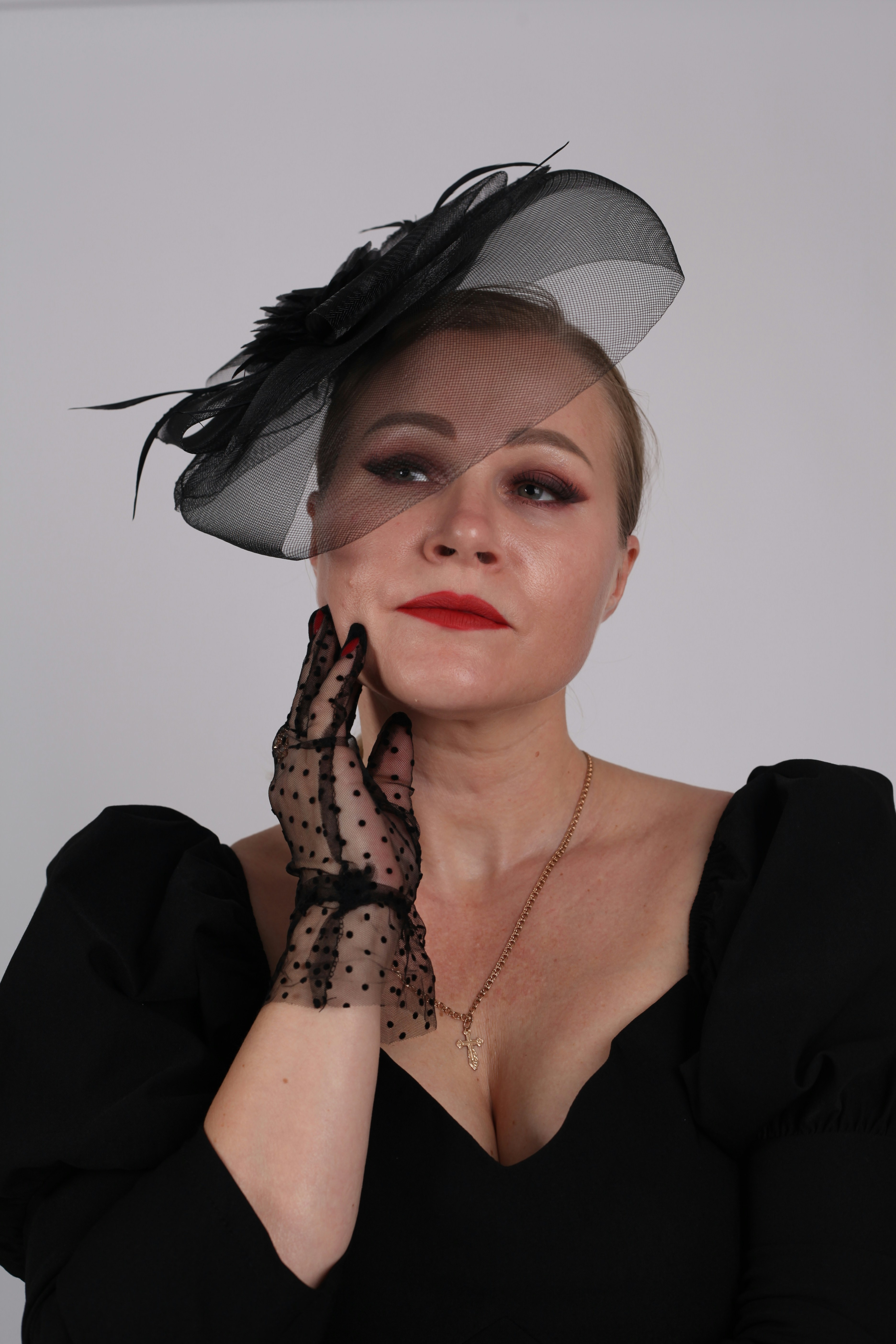 Woman in black dress and fascinator hat