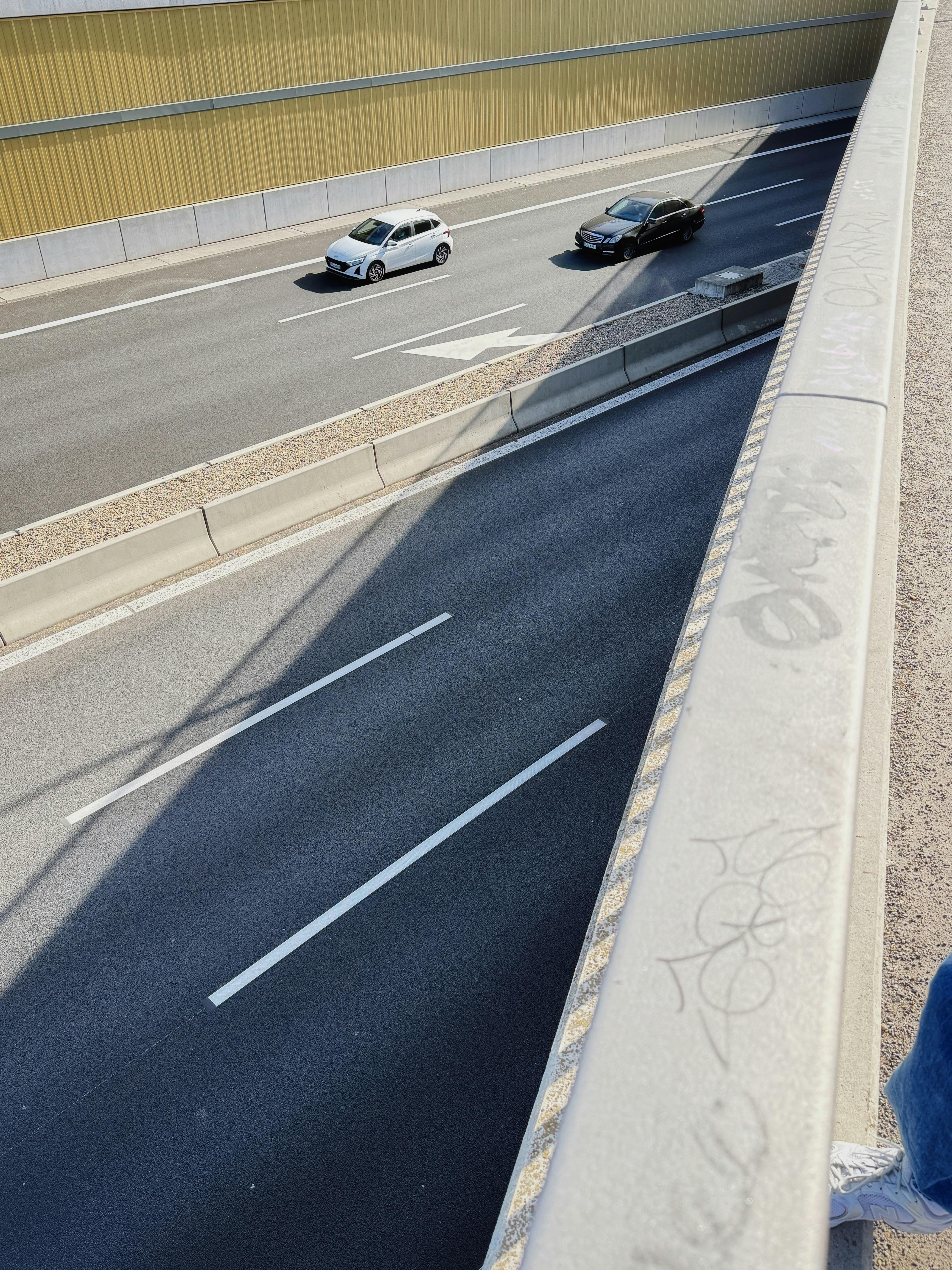 Auto che guidano su un'autostrada a più corsie sotto un ponte.