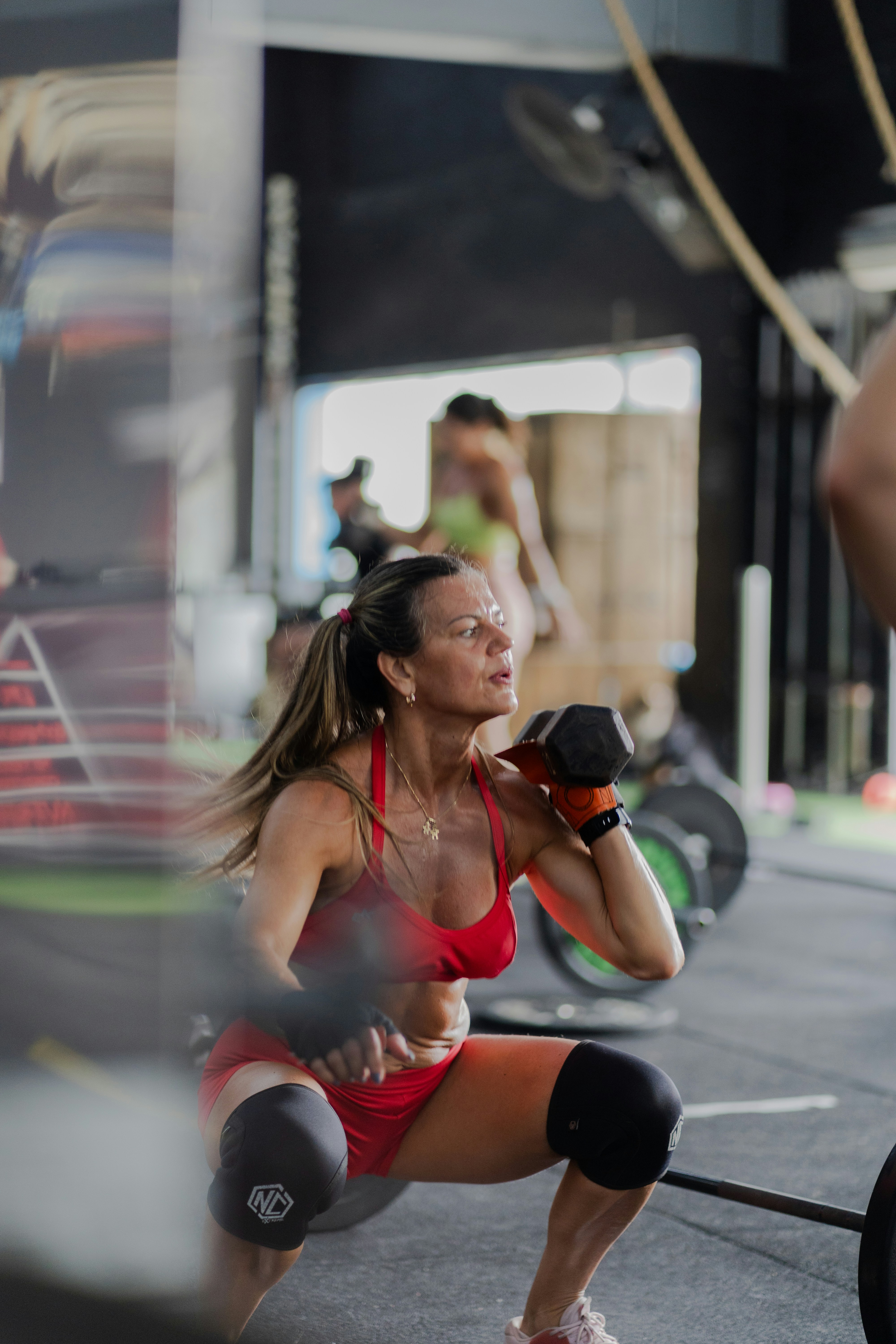 Mujer levantando mancuernas en gimnasio