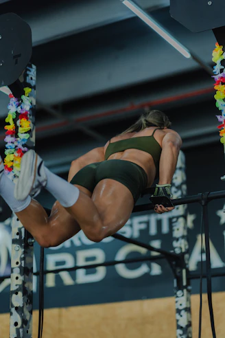 Woman performing muscle-ups on a pull-up bar