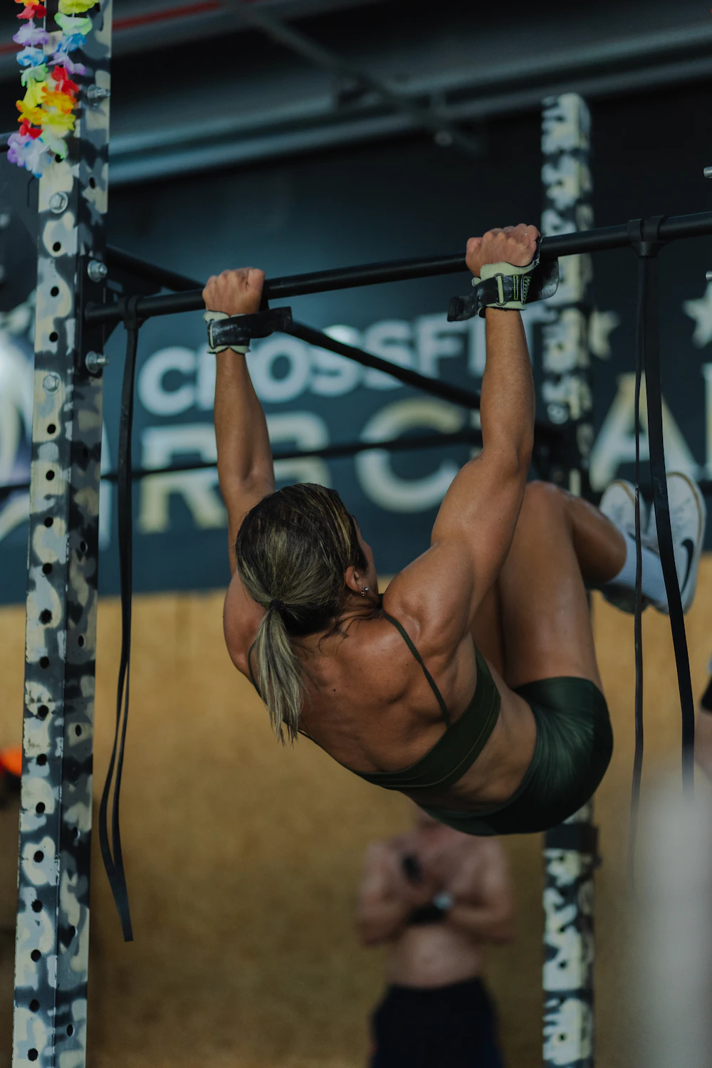 Person training on a pull-up bar in a gym
