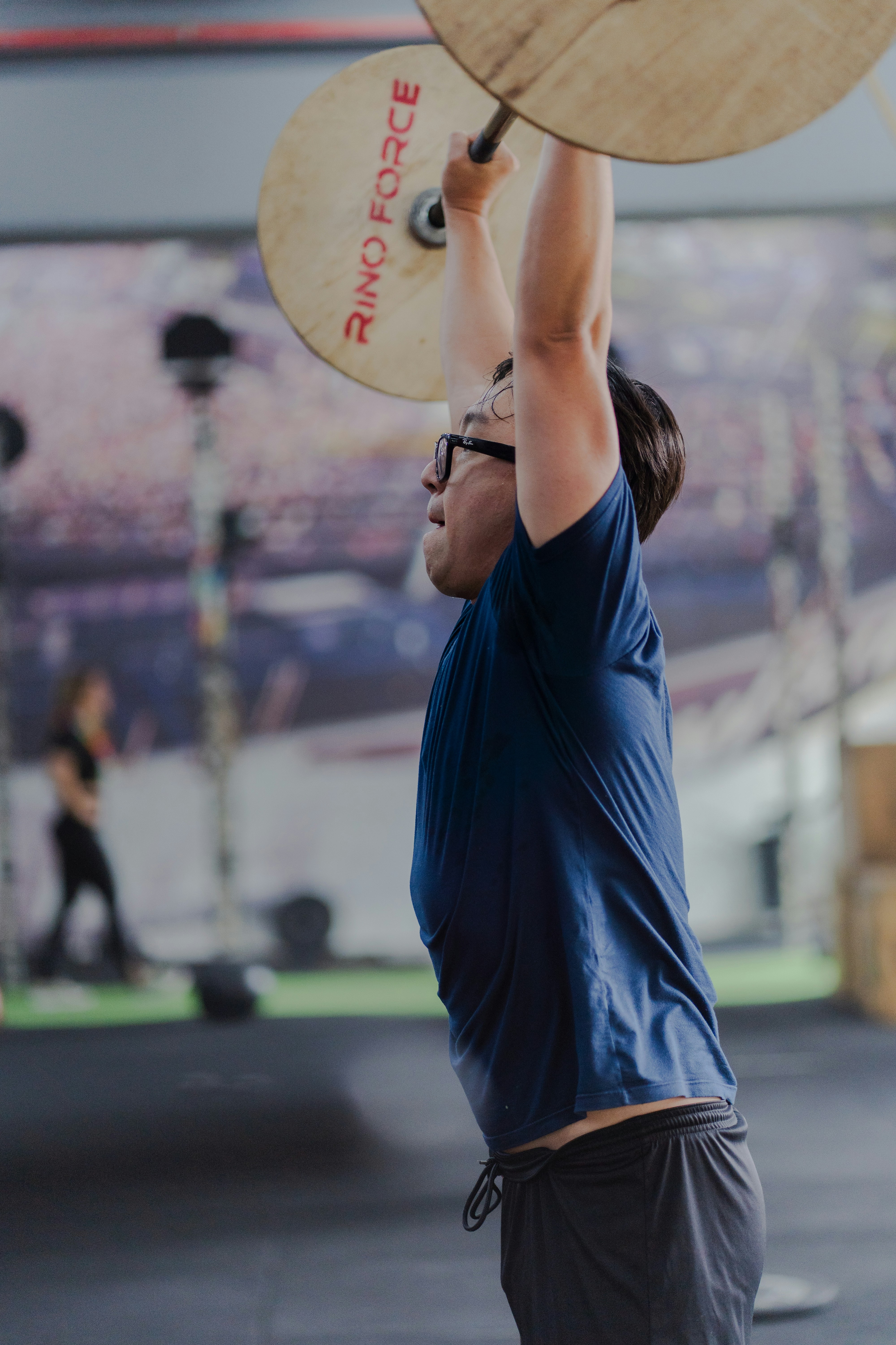 Man lifting weights overhead in a gym.