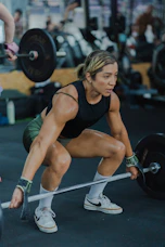Woman lifting a barbell in a gym