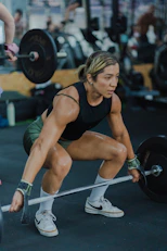 Woman lifting a barbell in a gym