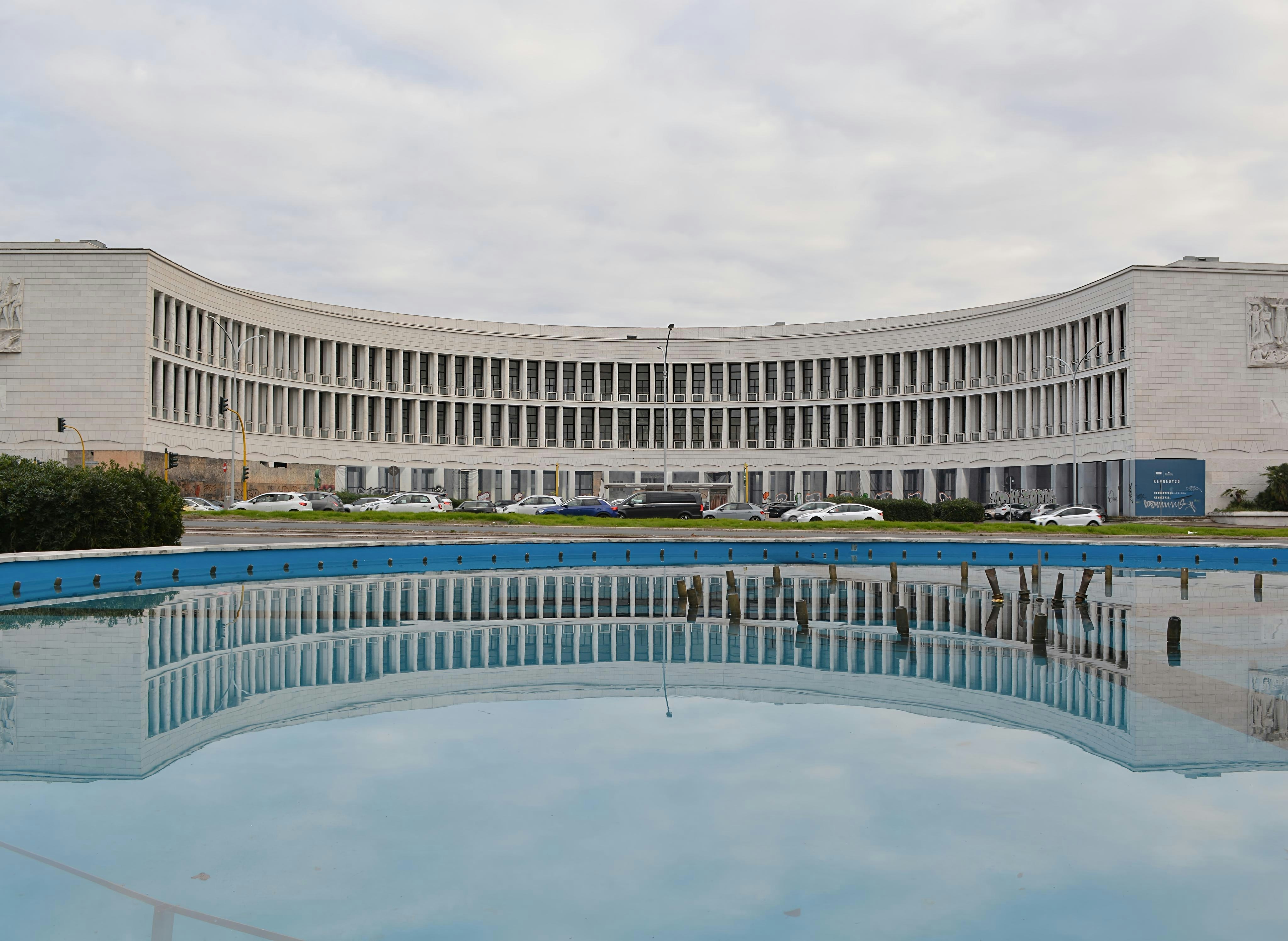 Curved building reflected in a pool of water