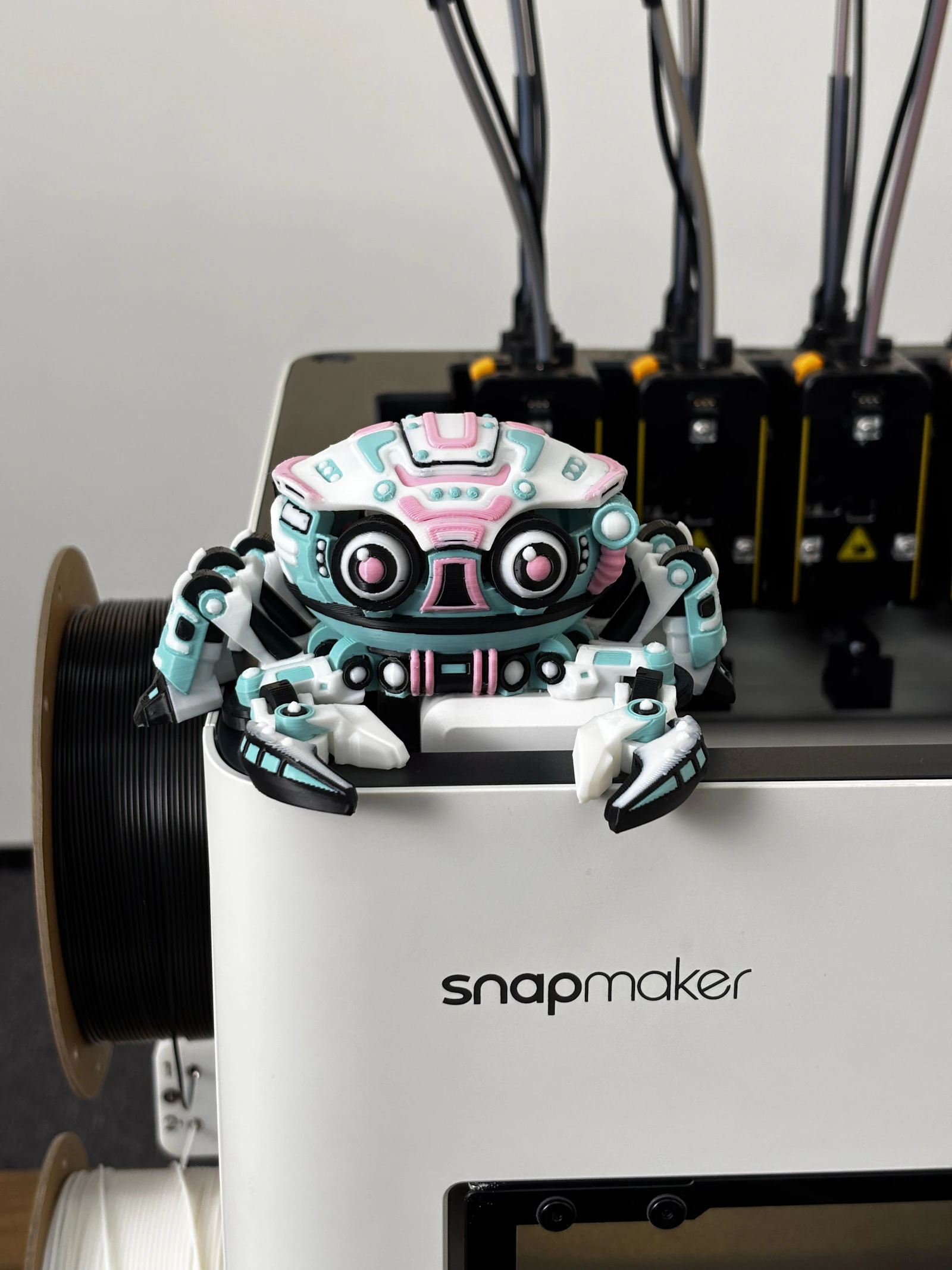 Colourful robot toy sitting on a 3D printer