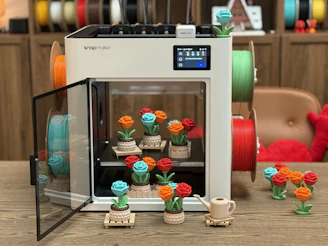 3D printer with colorful rose prints and filament spools