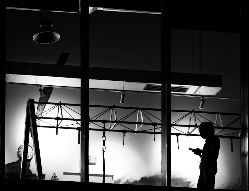 Silhouette of a person using a smartphone in the dark - shadow AI use in the workplace