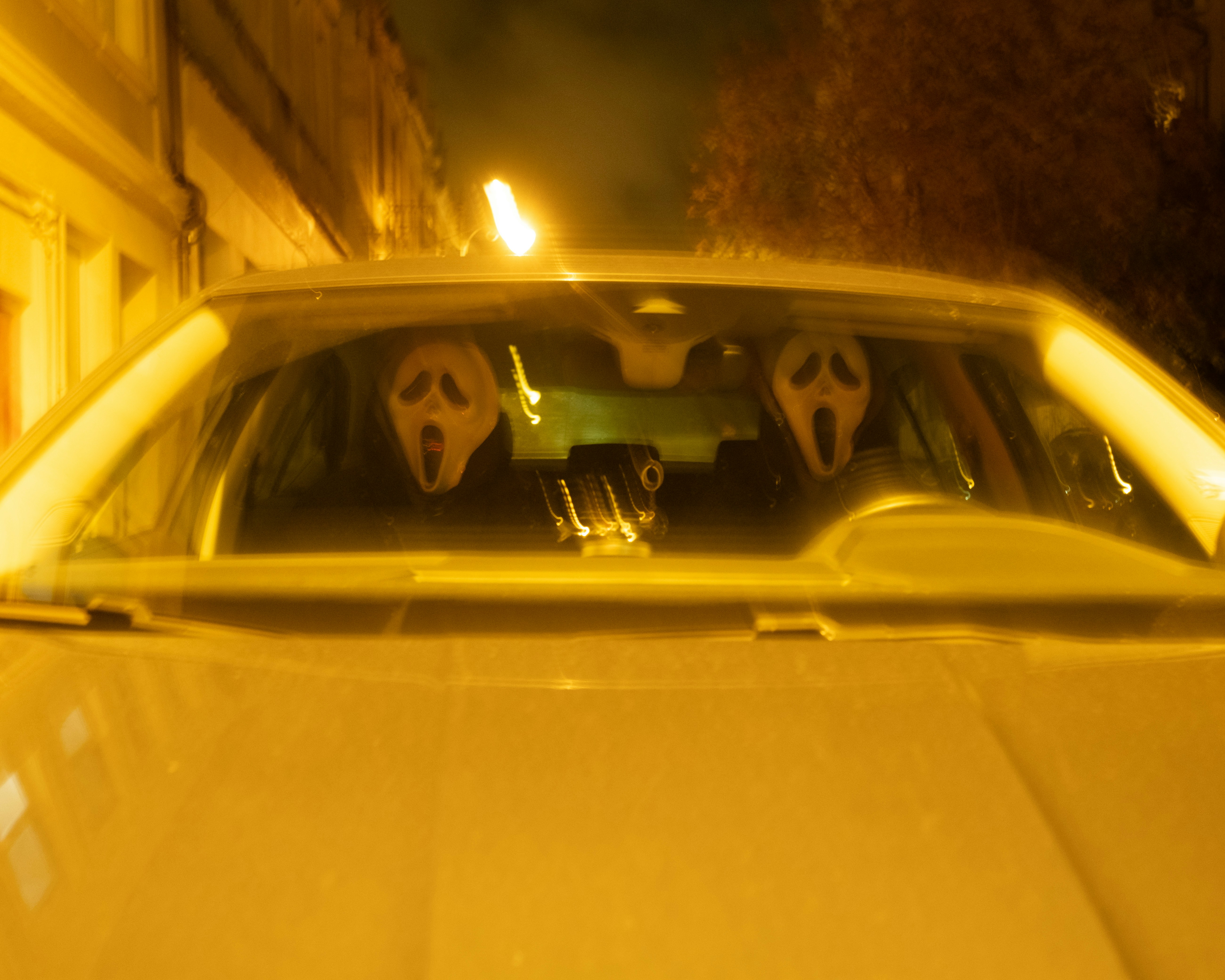 Two ghost masks in a car at night