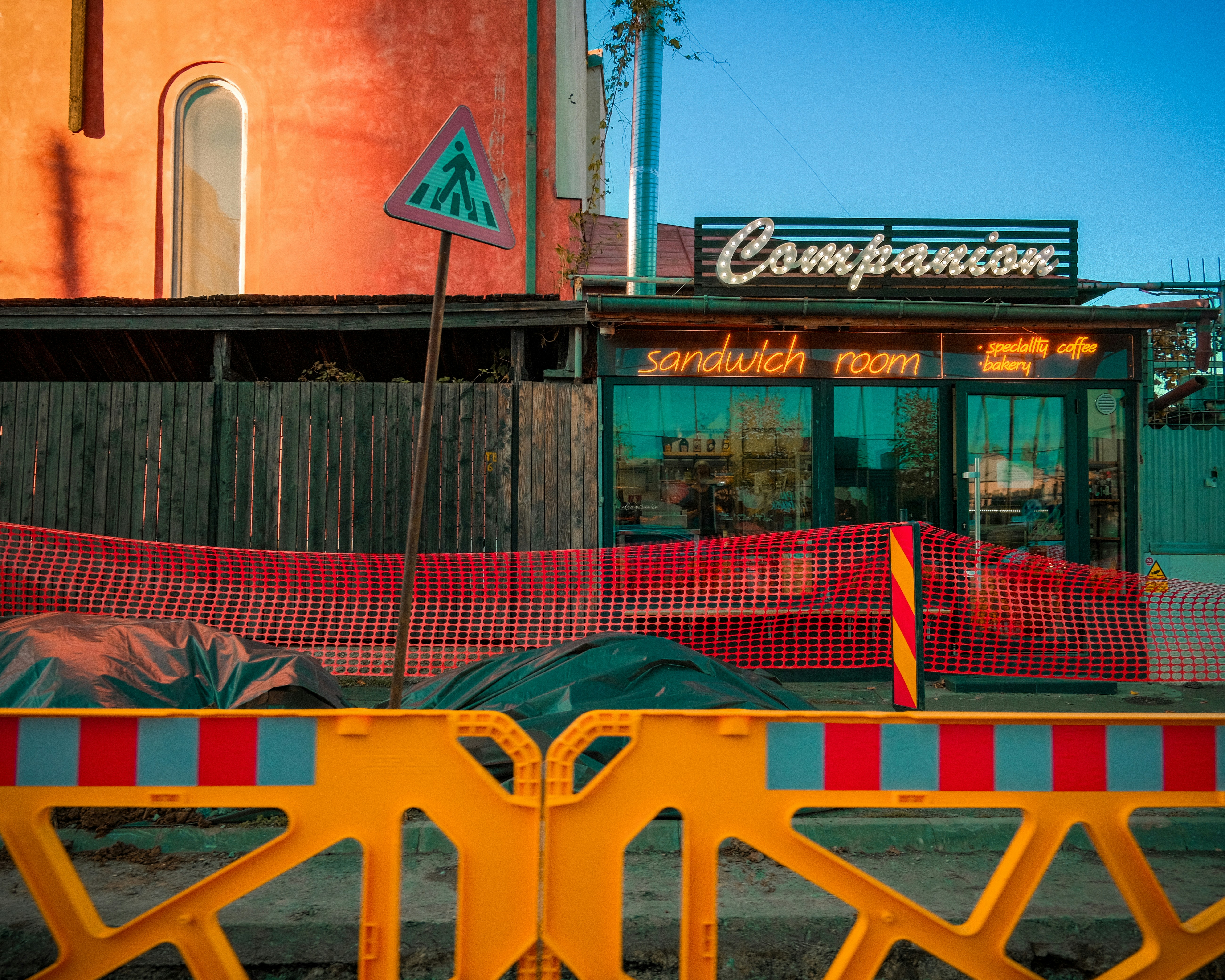 Sandwich room with neon sign and construction barriers