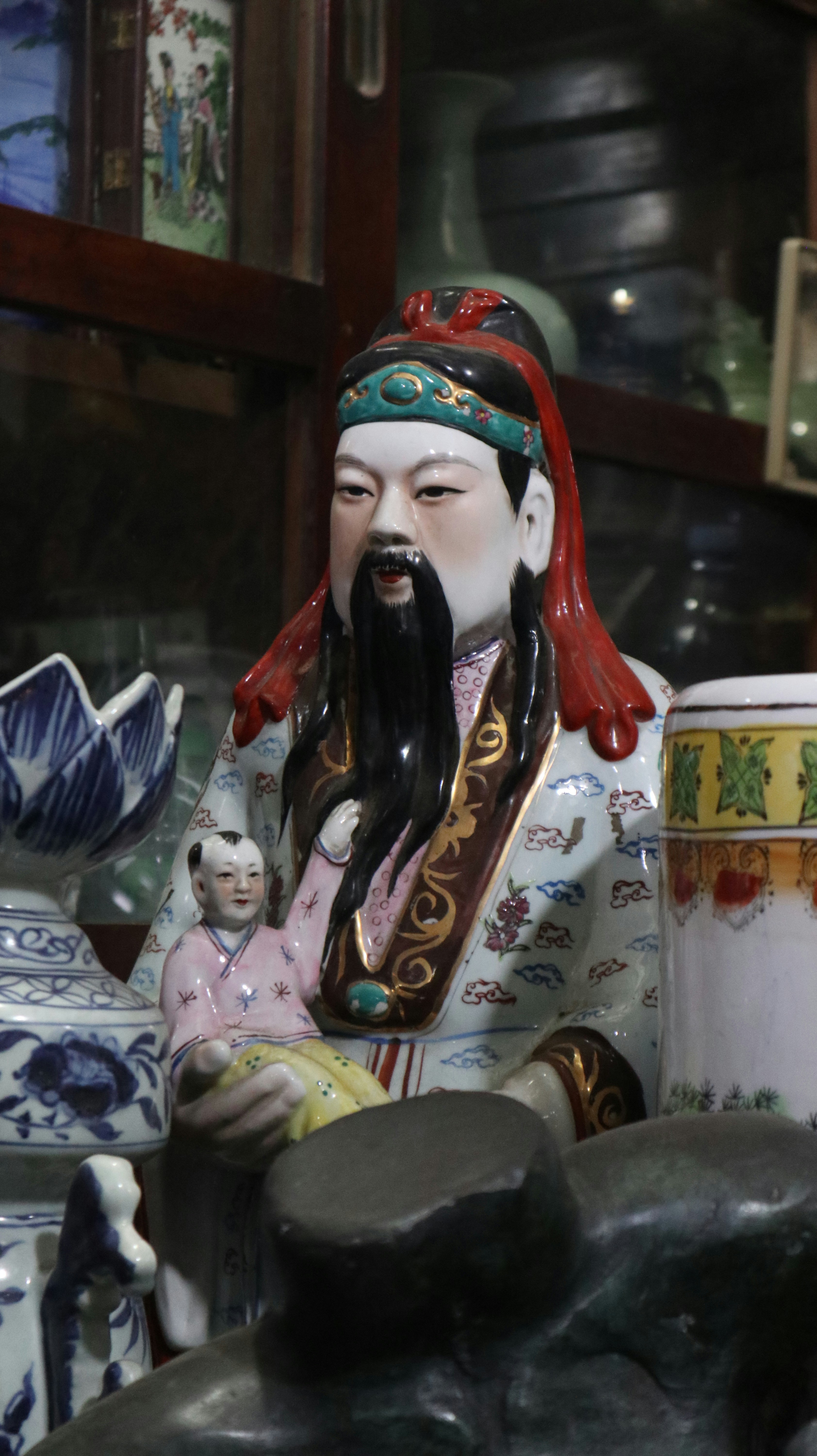 Porcelain statue of a man holding a child.