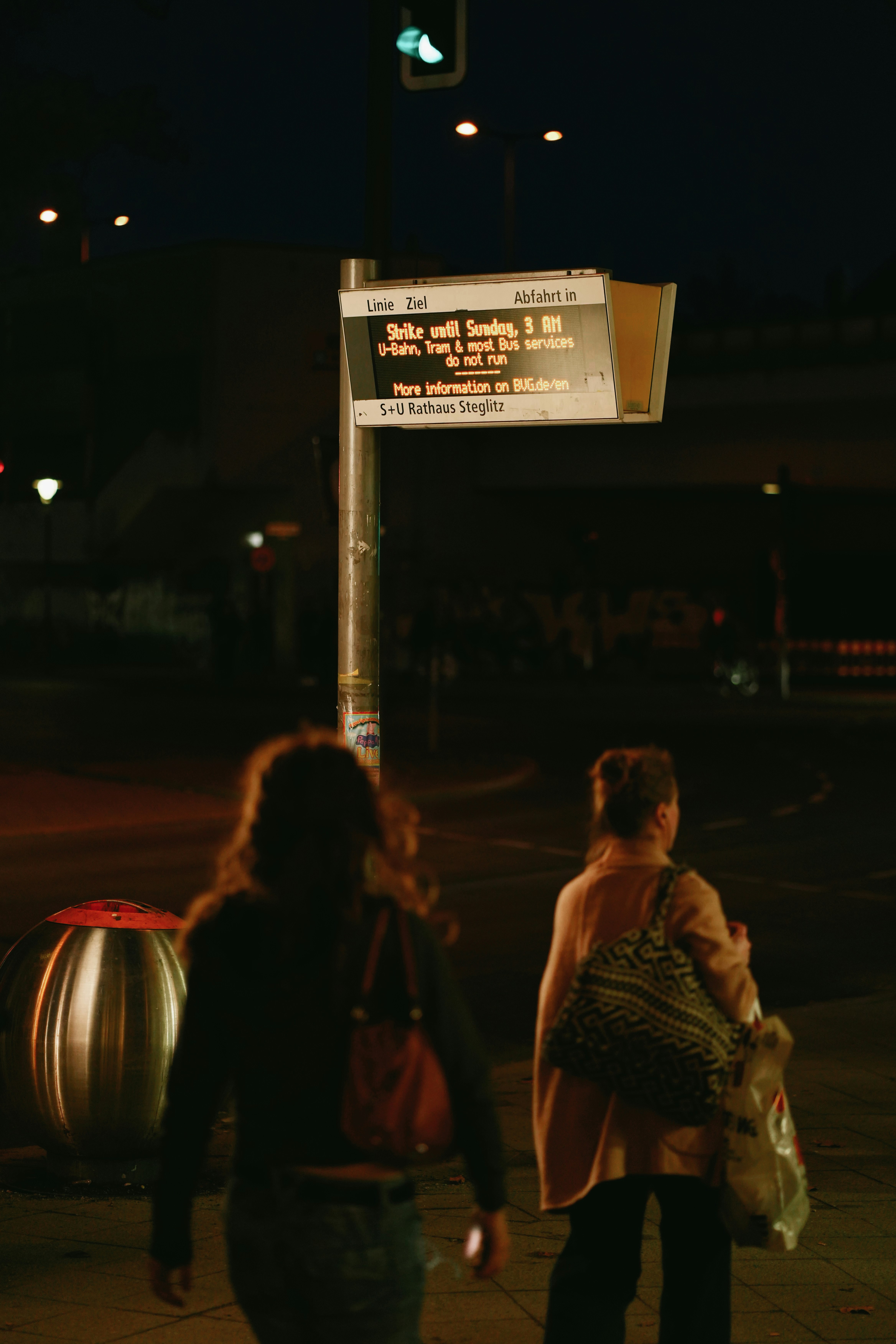 Zwei Frauen nachts an einer Bushaltestelle