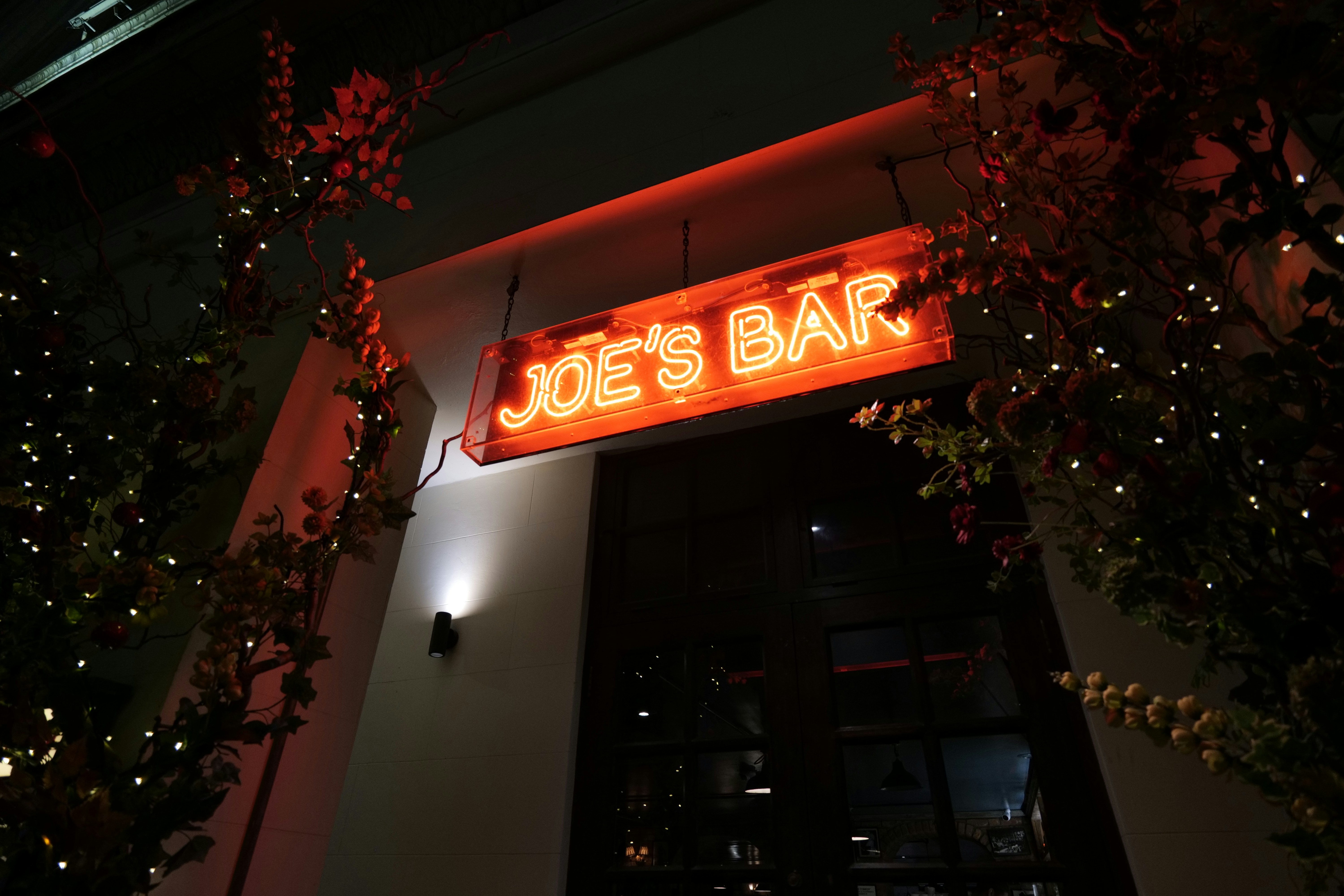 Joe's bar neon sign glows at night