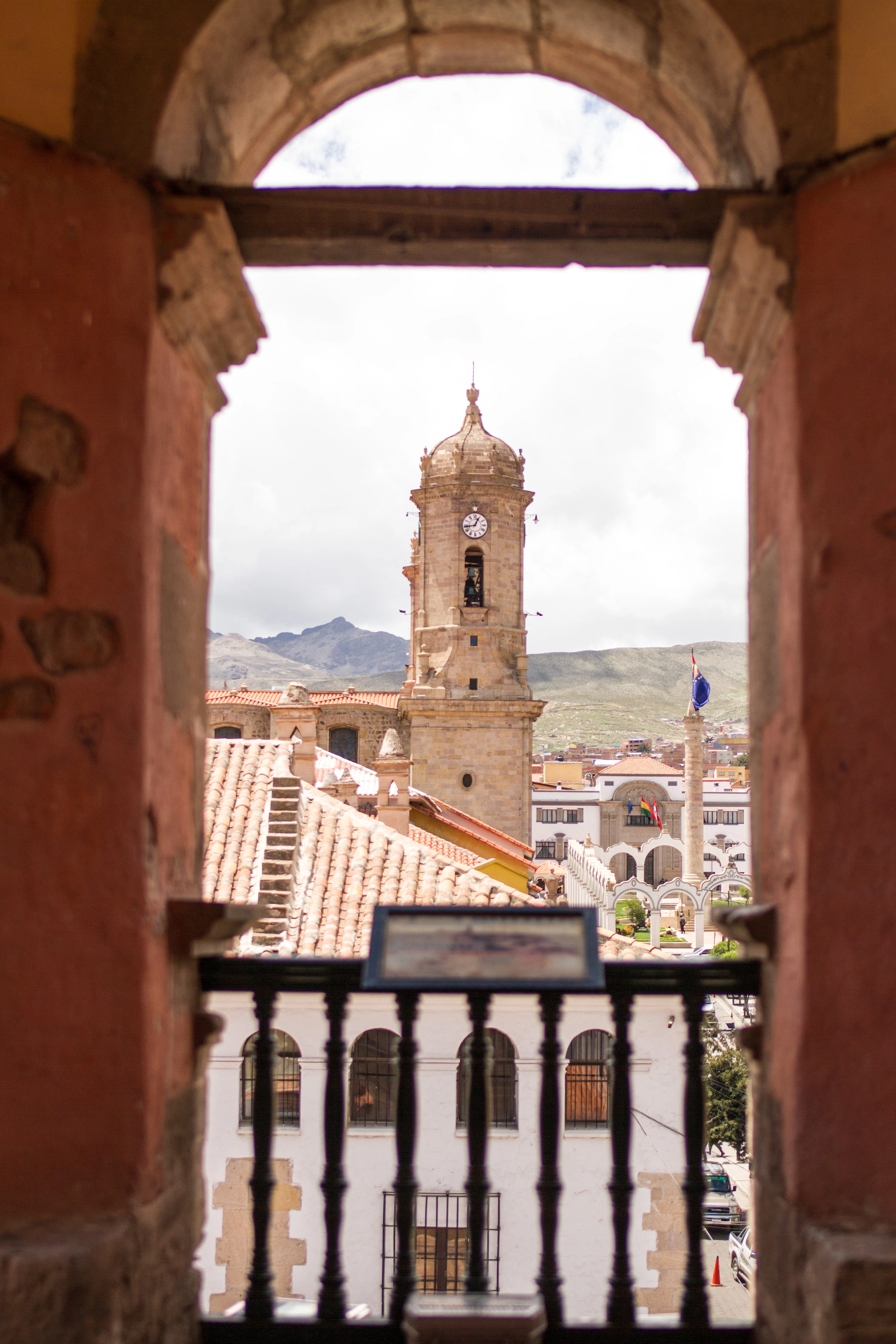 The cathedral tower of Potosí and the hills beyond, framed by a stone archway