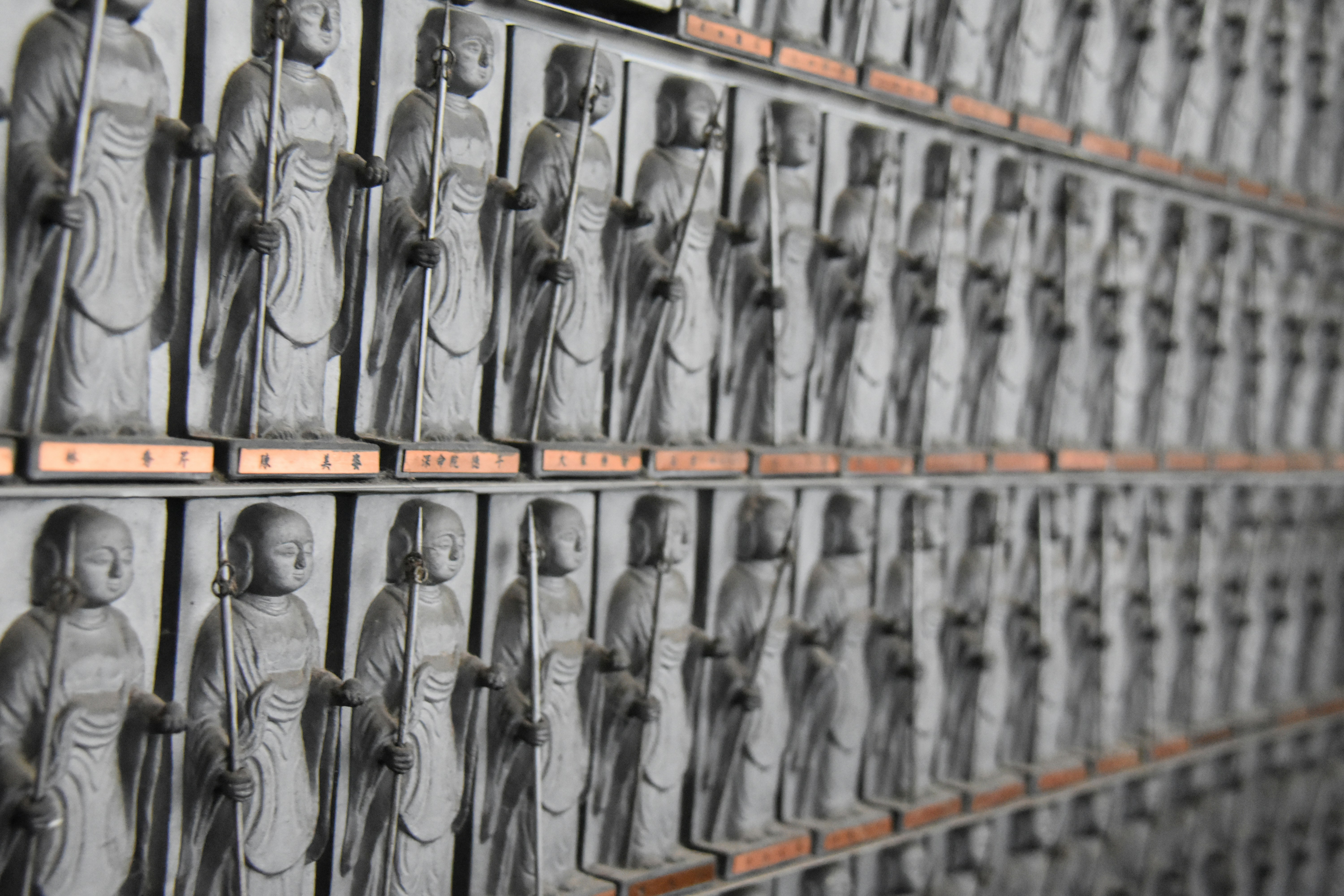 Fileiras de estátuas de pedra de figuras budistas